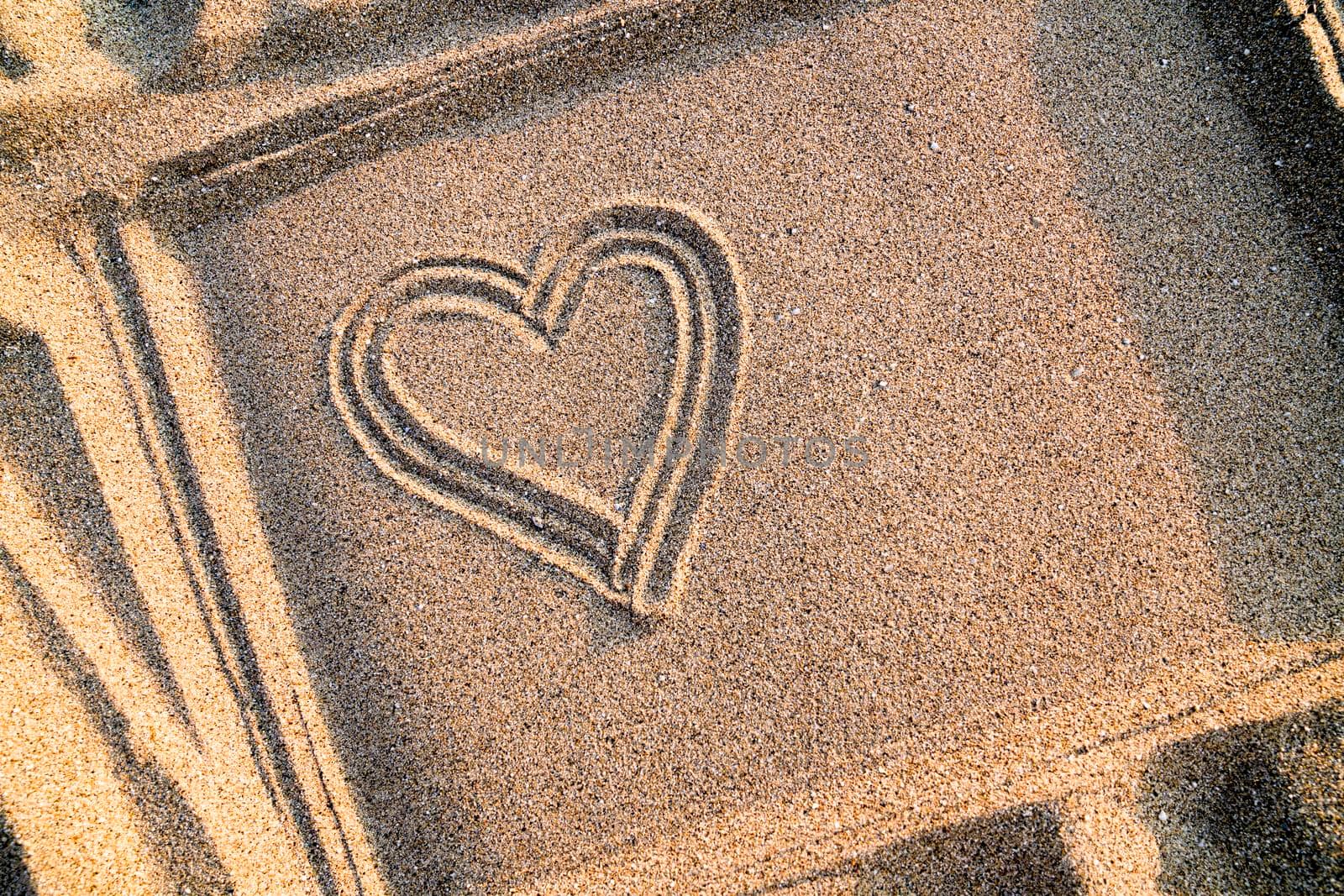 Heart drawn on the sand in a frame, close-up. Copy space. High quality photo