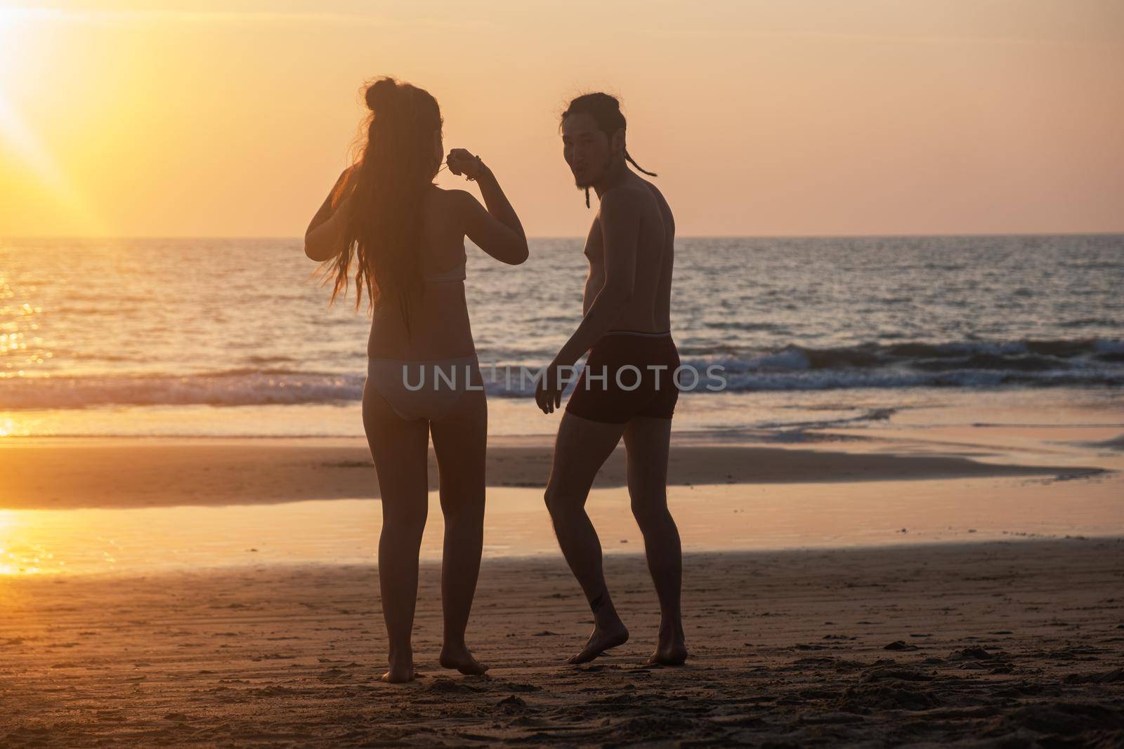 Silhouette of a young couple together at the beach by snep_photo