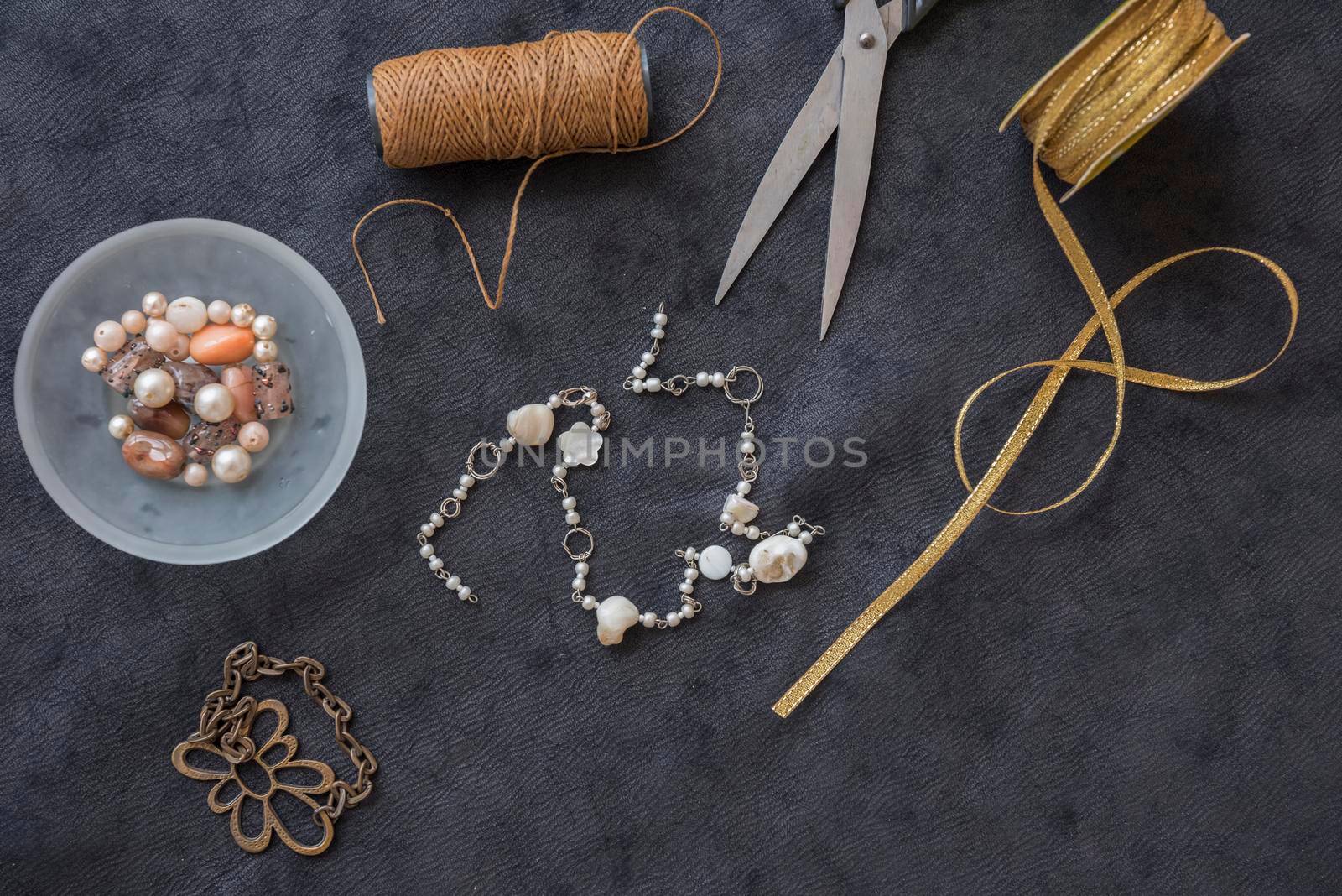 bracelet made with yarn spool beads scissor golden ribbon black textured backdrop by Zahard