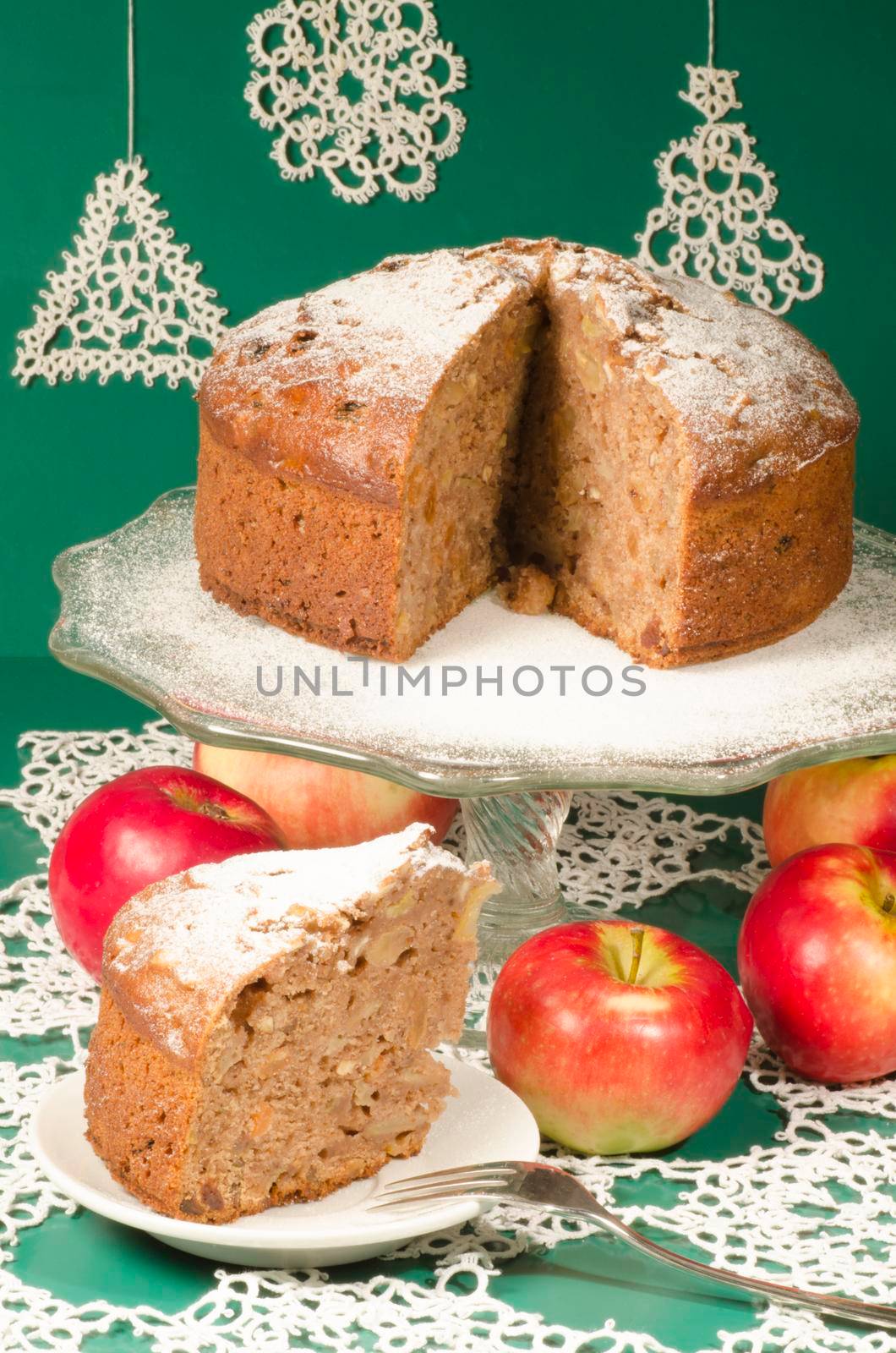 Applesauce raisin rum cake for christmas table. Table decorated with lacy snowflakes and napkin. From series of "Merry Christmas"