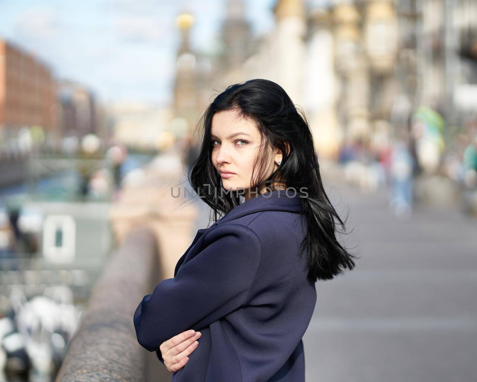 Portrait f beautiful intelligent brunette who walks down street of Saint-Petersburg in city center. Charming thoughtful woman with long dark hair wanders alone, immersed in thoughts by NataBene