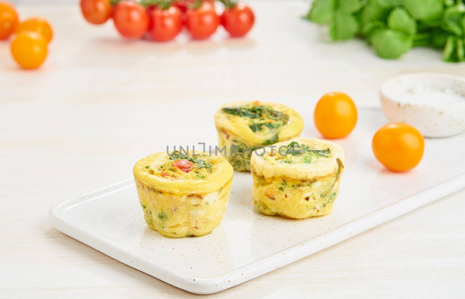 Egg muffins, paleo, keto diet. Omelet with spinach, vegetables, tomatoes baked in small molds