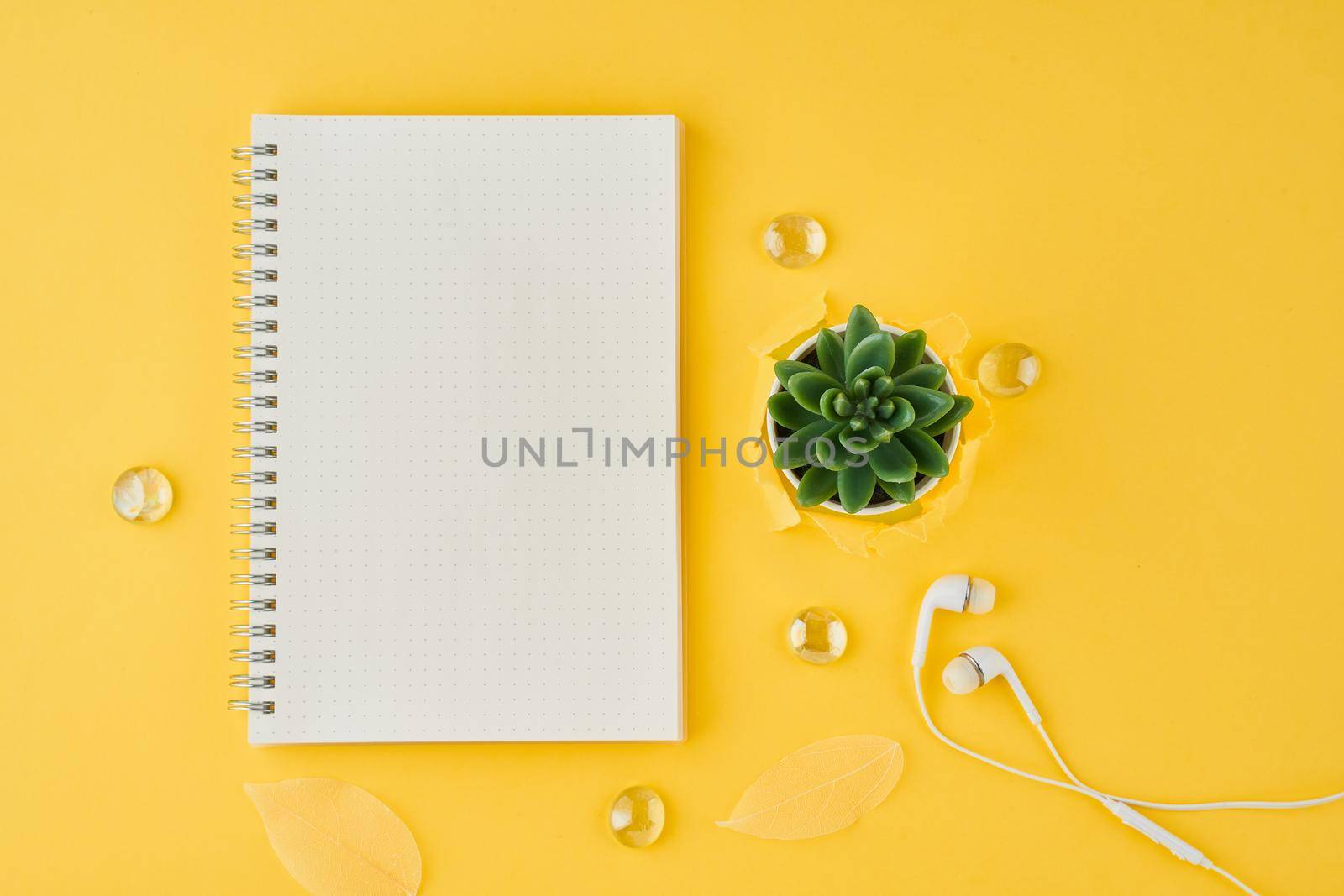 Blank notepad page in bullet journal on bright yellow office desktop. Top view of a modern bright table with notebook, minimalism. Mock up, copy space, concept for diary