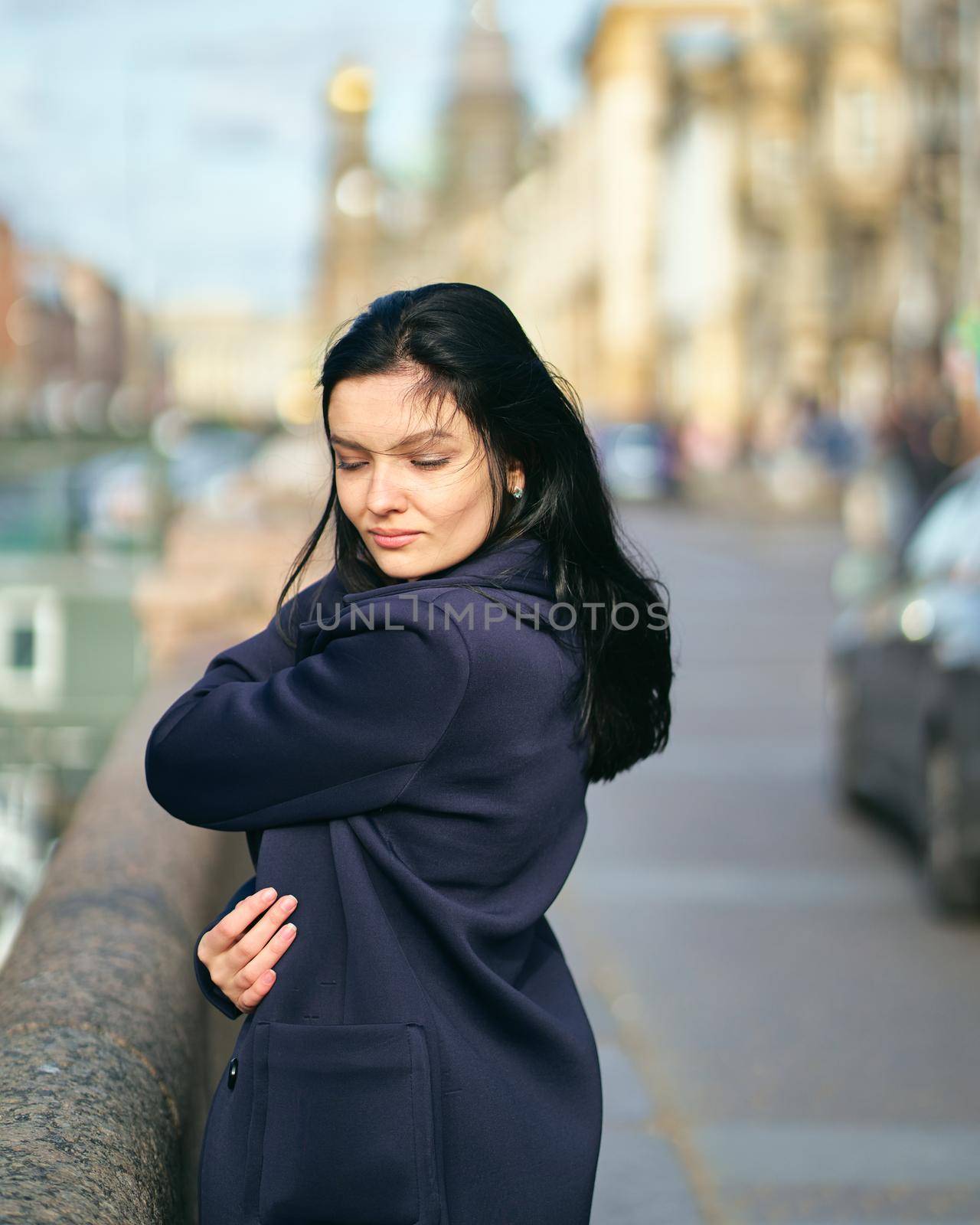 Portrait f beautiful intelligent brunette who walks down street of Saint-Petersburg in city center. Charming thoughtful woman with long dark hair wanders alone, immersed in thoughts by NataBene