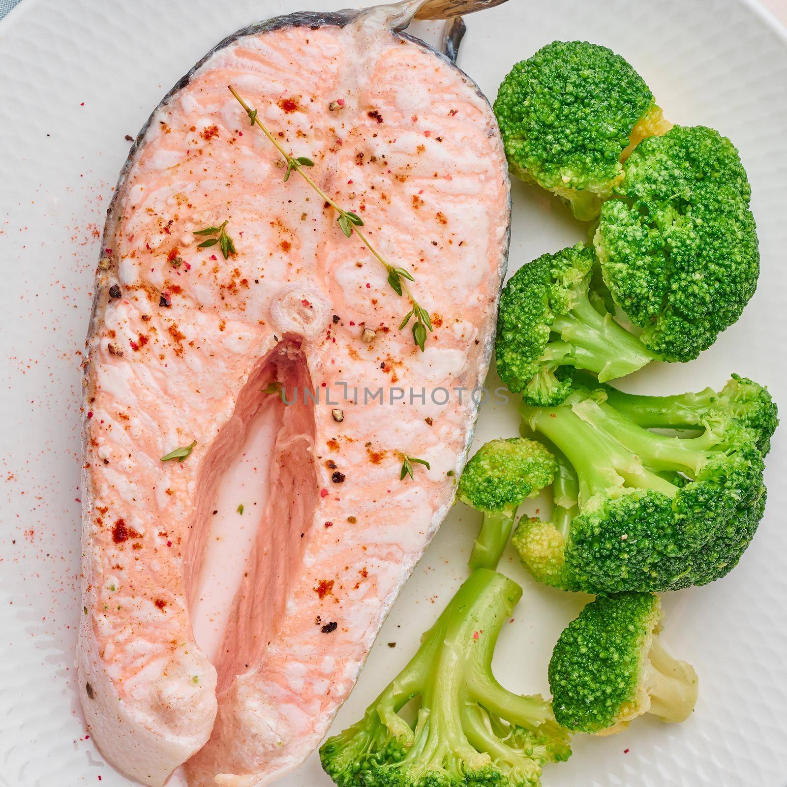 Steam salmon, broccoli, paleo, keto or fodmap diet. White plate on a blue table, top view, close up