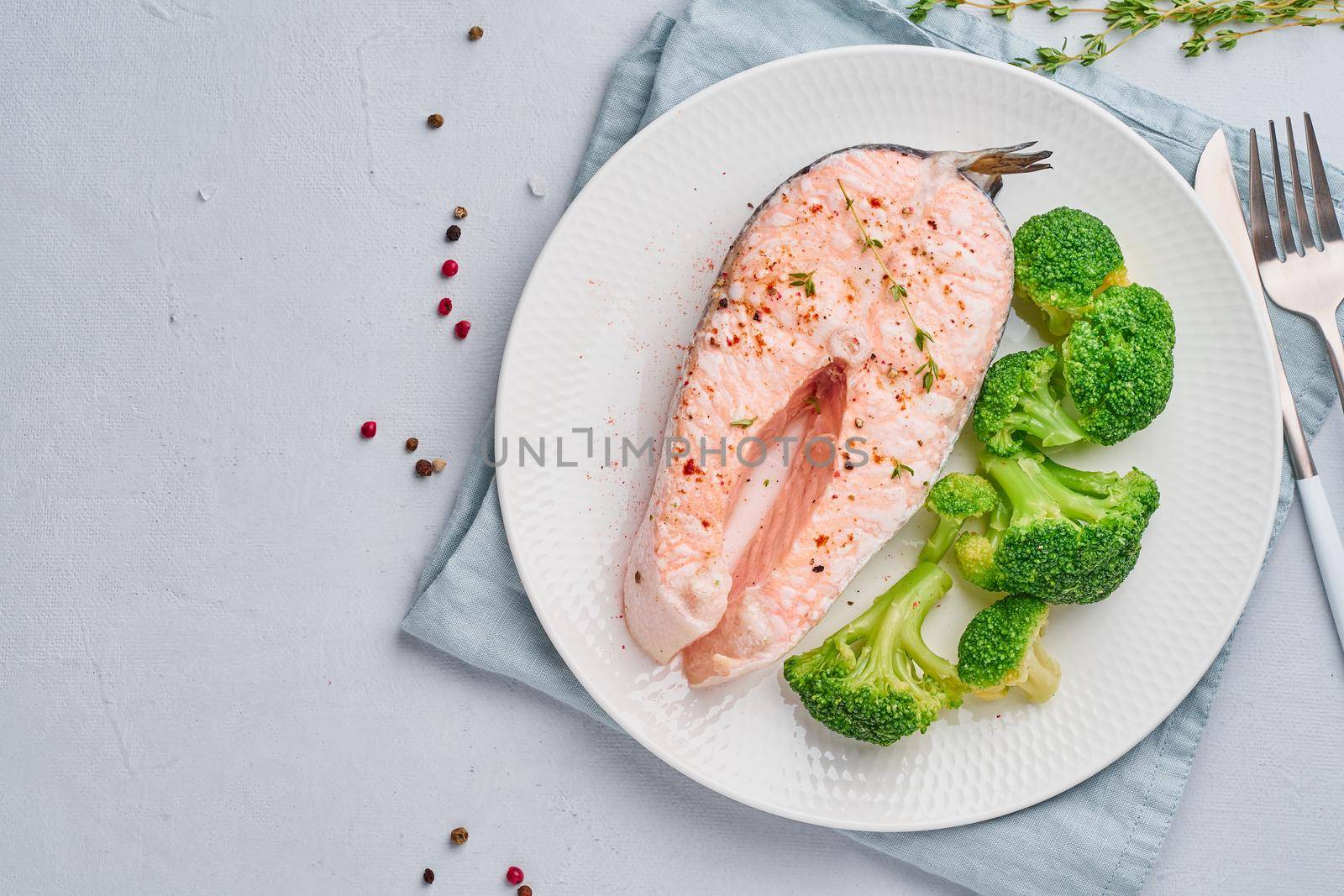 Steam salmon, broccoli, paleo, keto or fodmap diet. White plate on a blue table, top view, copy space