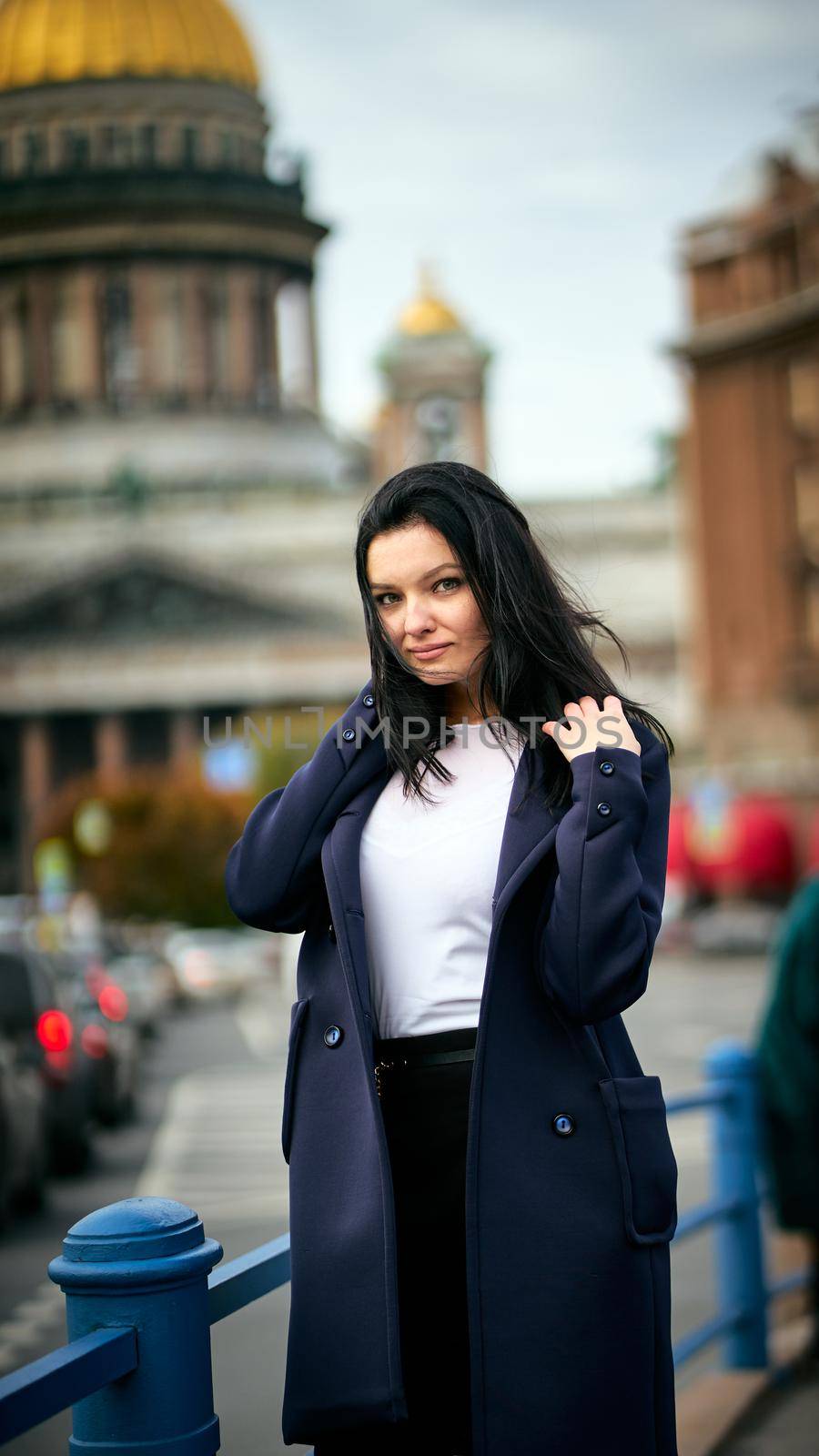 Charming thoughtful fashionably dressed woman with long dark hair travels through Europe, standing in city center of St. Petersburg, thoughtful woman with long dark hair wanders alone by NataBene