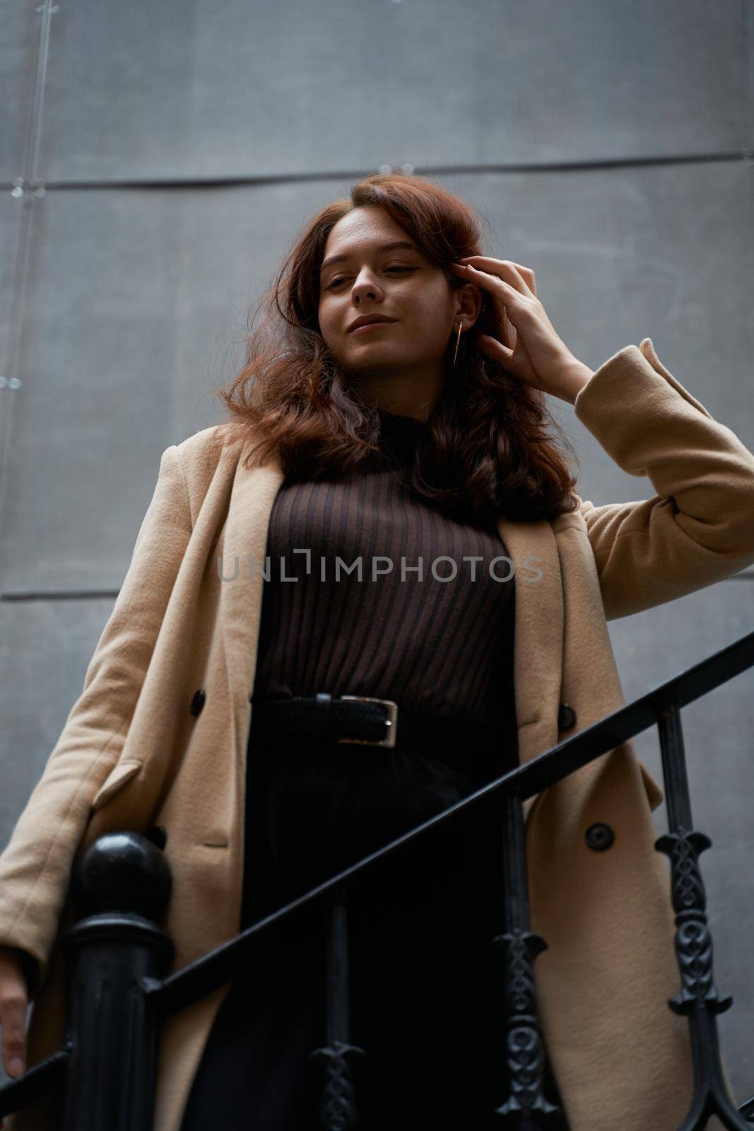 Beautiful serious stylish fashionable smart girl standing on the stairs, St. Petersburg city. Charming thoughtful woman with long dark hair, shooting from below by NataBene