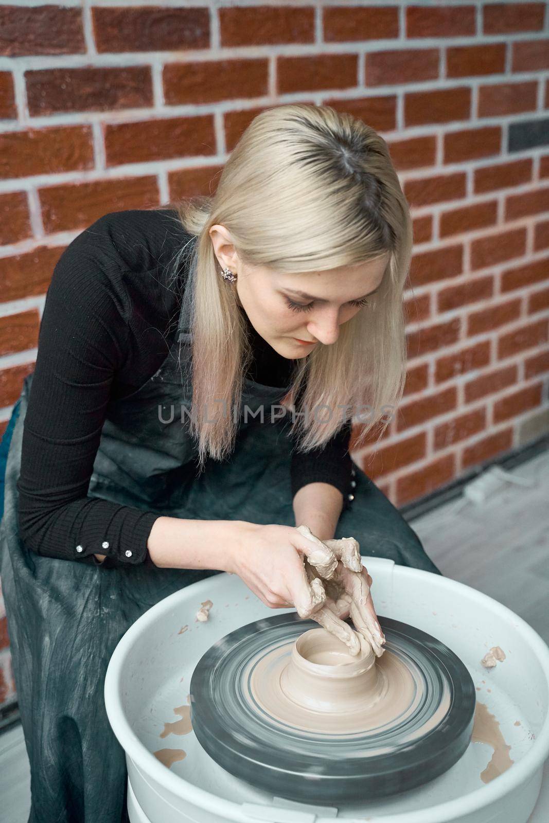 Woman making ceramic pottery on wheel, hands closeup. Concept for woman in freelance, business, hobby. Earn extra money, turning hobbies into cash, Turning passion into job by NataBene