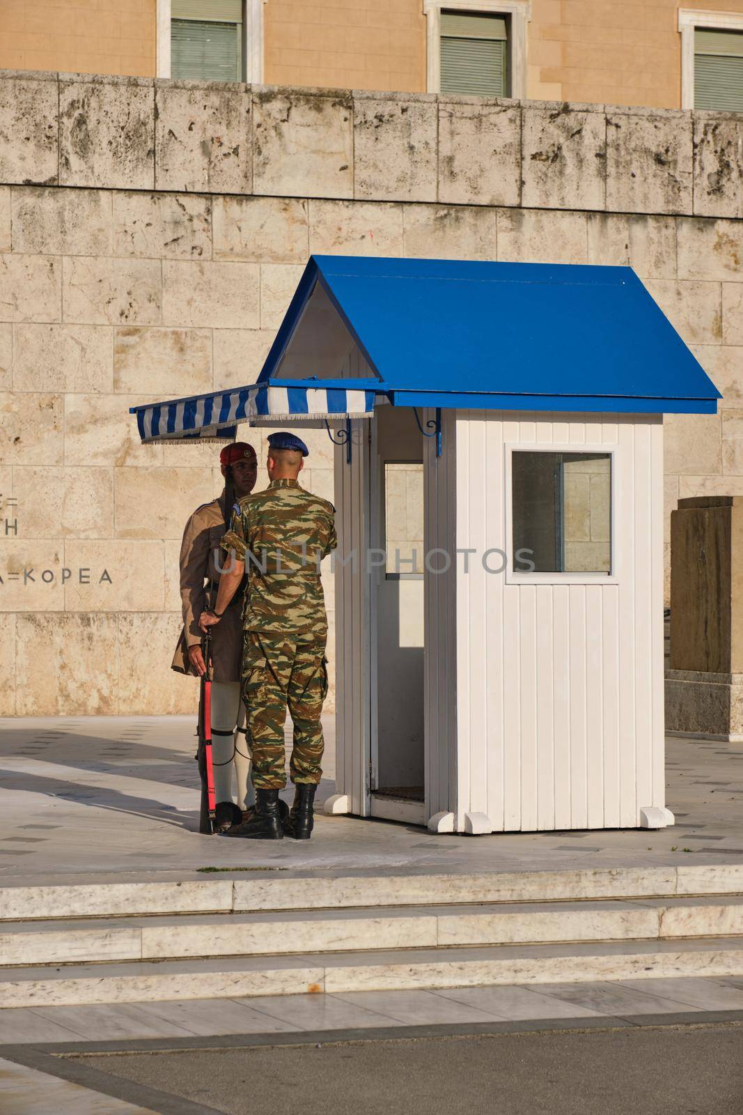 ATHENS, GREECE - MAY 20, 2010: Supervising Corporal of the Change fixes presidential ceremonial guard Evzone costume in front of the Monument of the Unknown Soldier near Greek Parliament, Syntagma square, Athenes, Greece