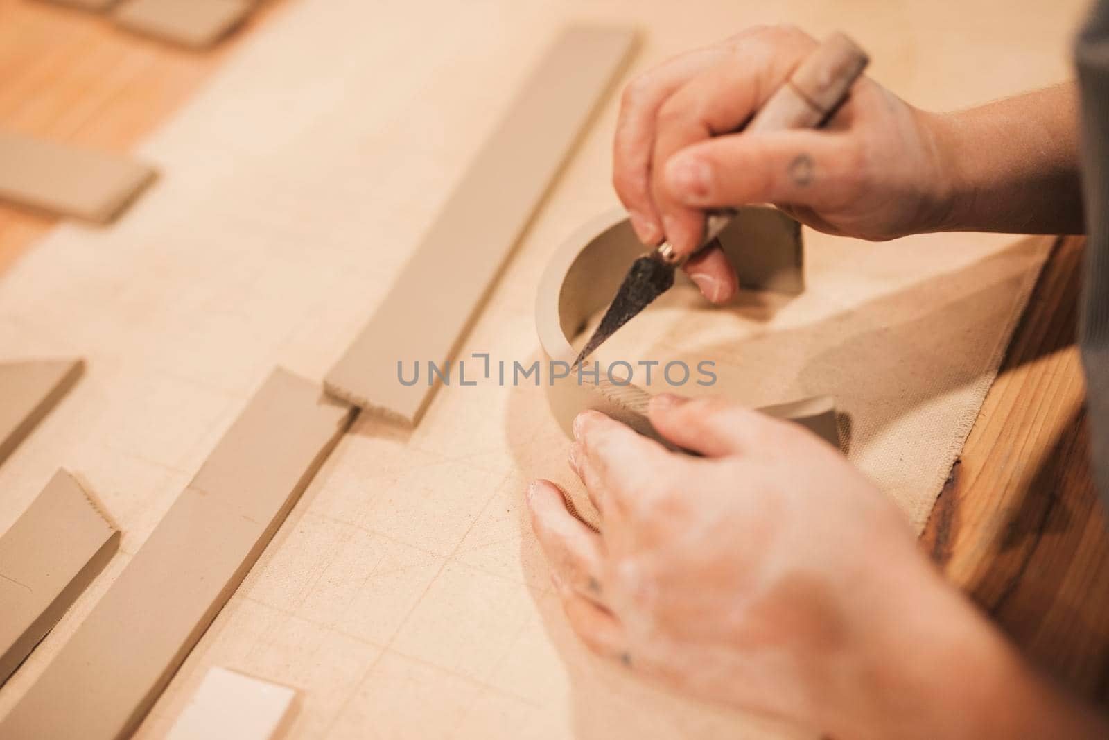 female potter s hand engraving clay with tools wooden table by Zahard