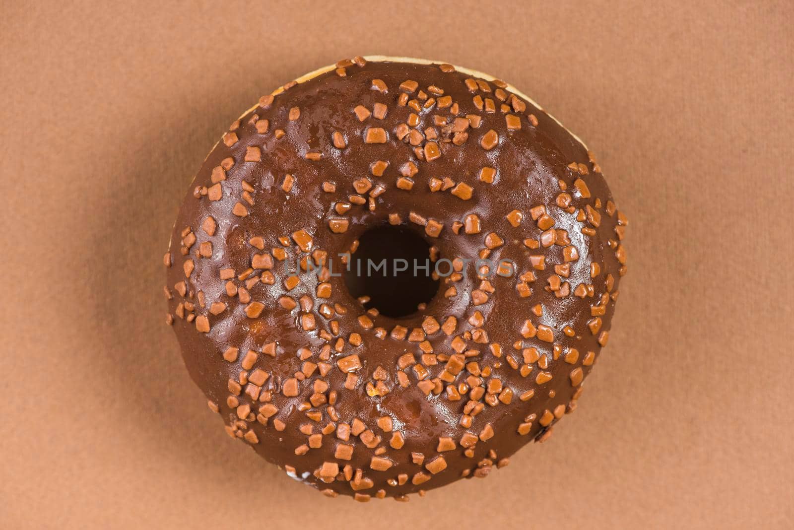 dark chocolate doughnut with sprinkles brown background by Zahard