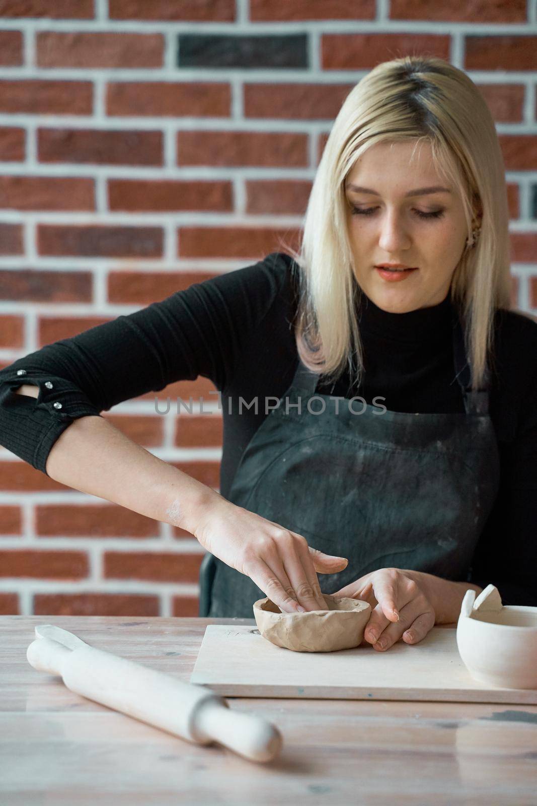 Woman making ceramic pottery. Concept for woman in freelance, business. Handcraft product. Earn extra money, side hustle, turning hobbies into cash and passion into job by NataBene