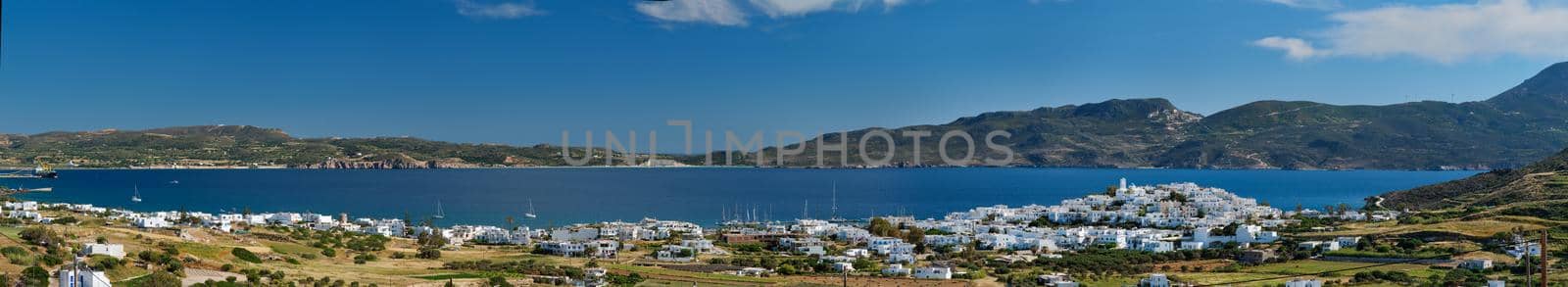 Panorama of Plaka village with traditional Greek church white painted Greek houses and ocean coast. Milos island, Greece