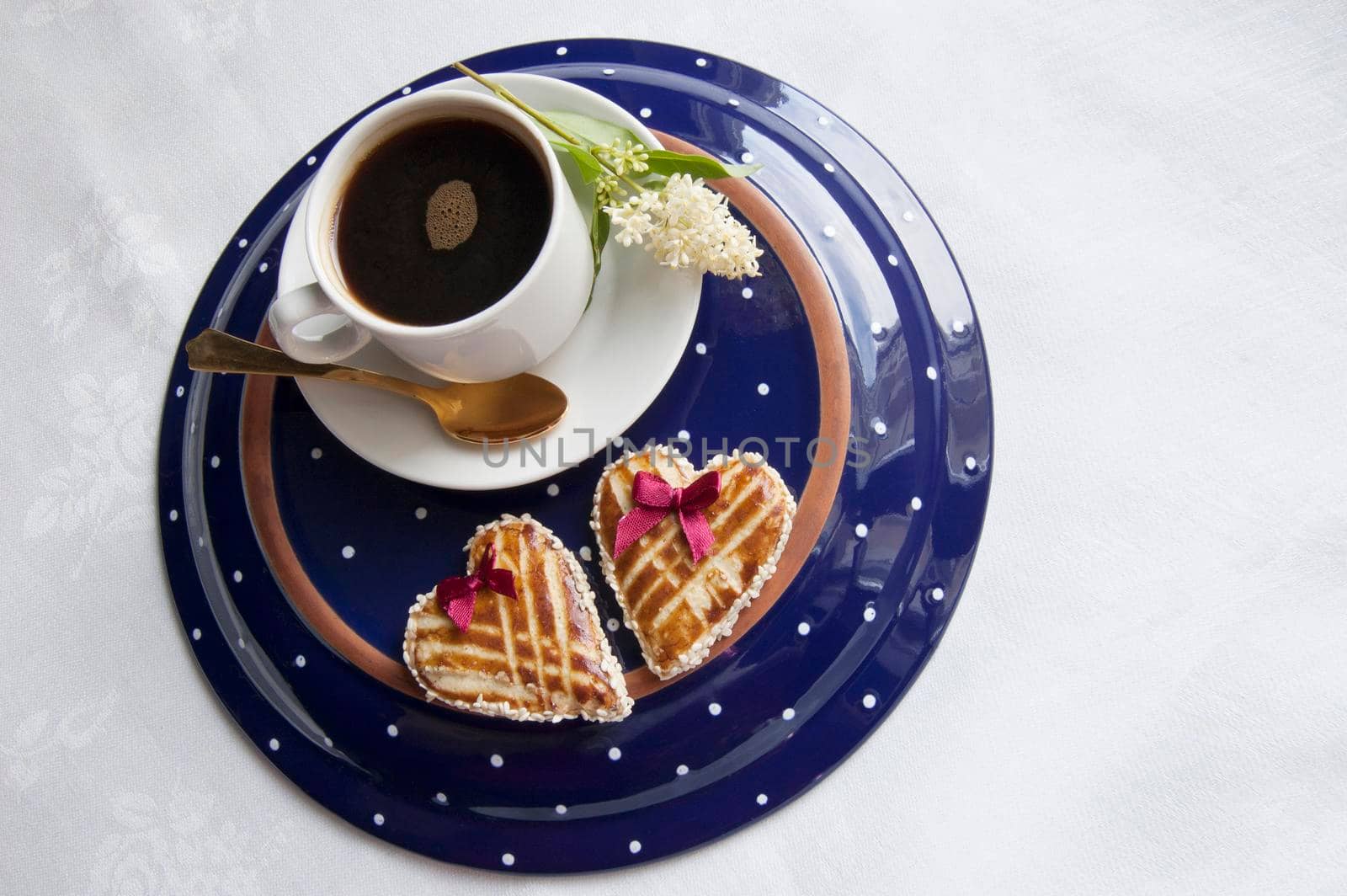 Cookies in the shape of heart on the table. Near a beautiful flower. Retro style. From the series "Valentine's Day Cookies"