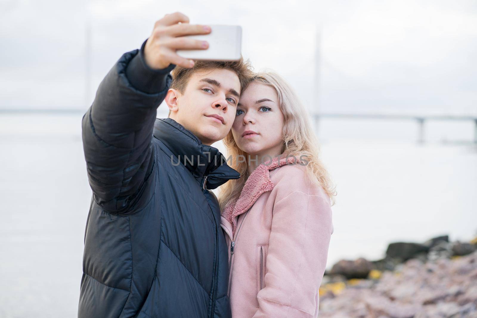 Teenage love concept. Cute brunette guy young blonde girl by NataBene