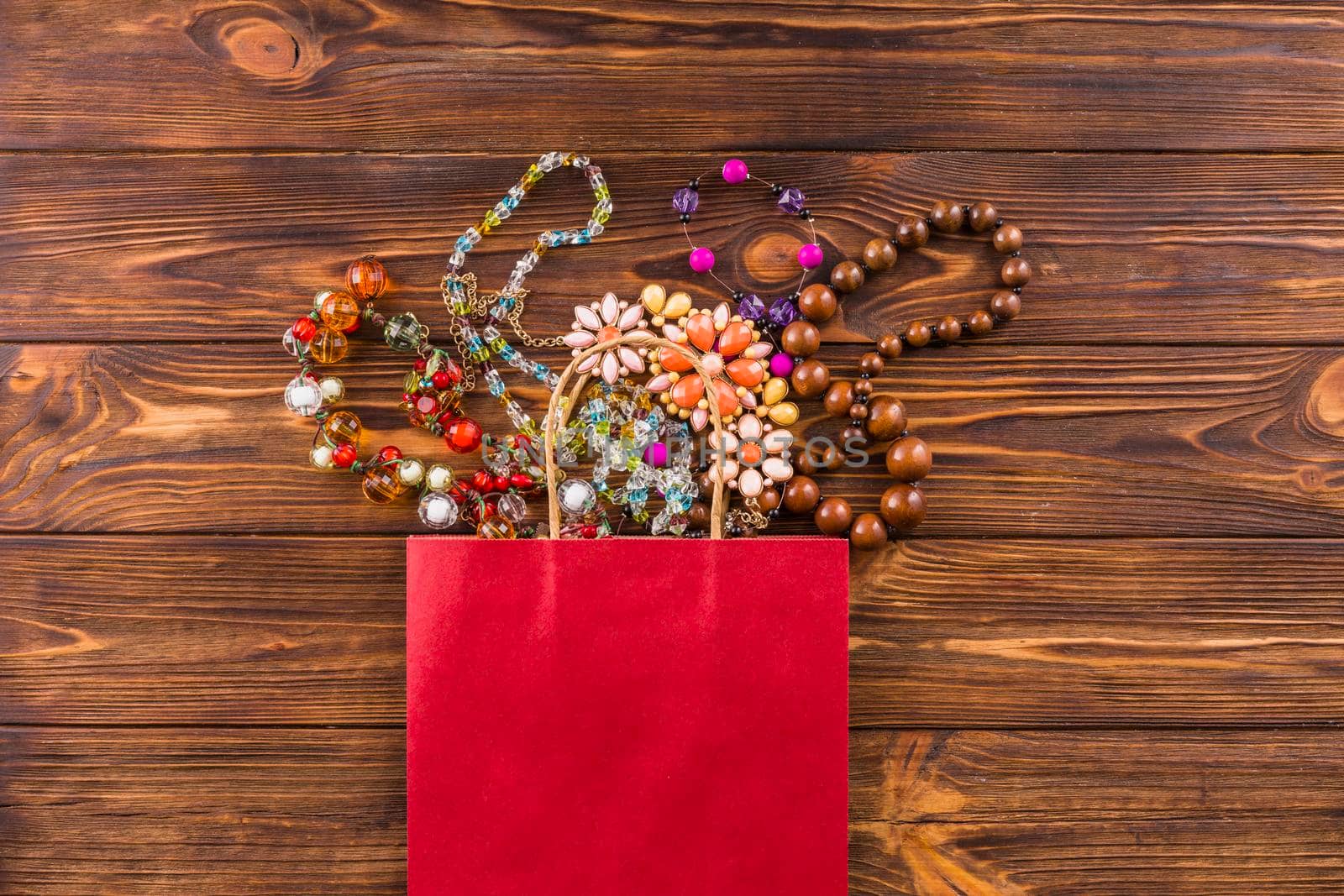 beads jewelry red paper bag wooden background by Zahard