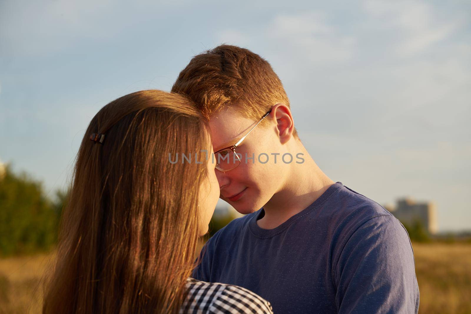 teenagers flirting, concept of teen love, boy looking at girl in field