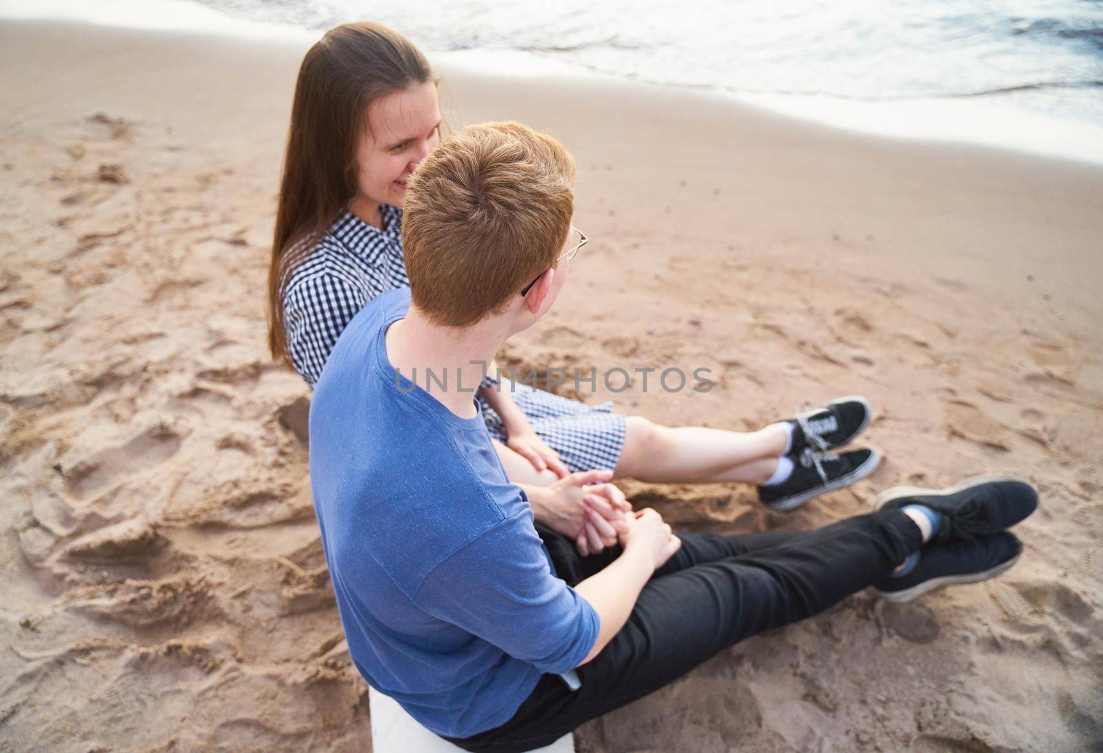 teenagers talking to each other, sitting on the beach, teen love and bonding