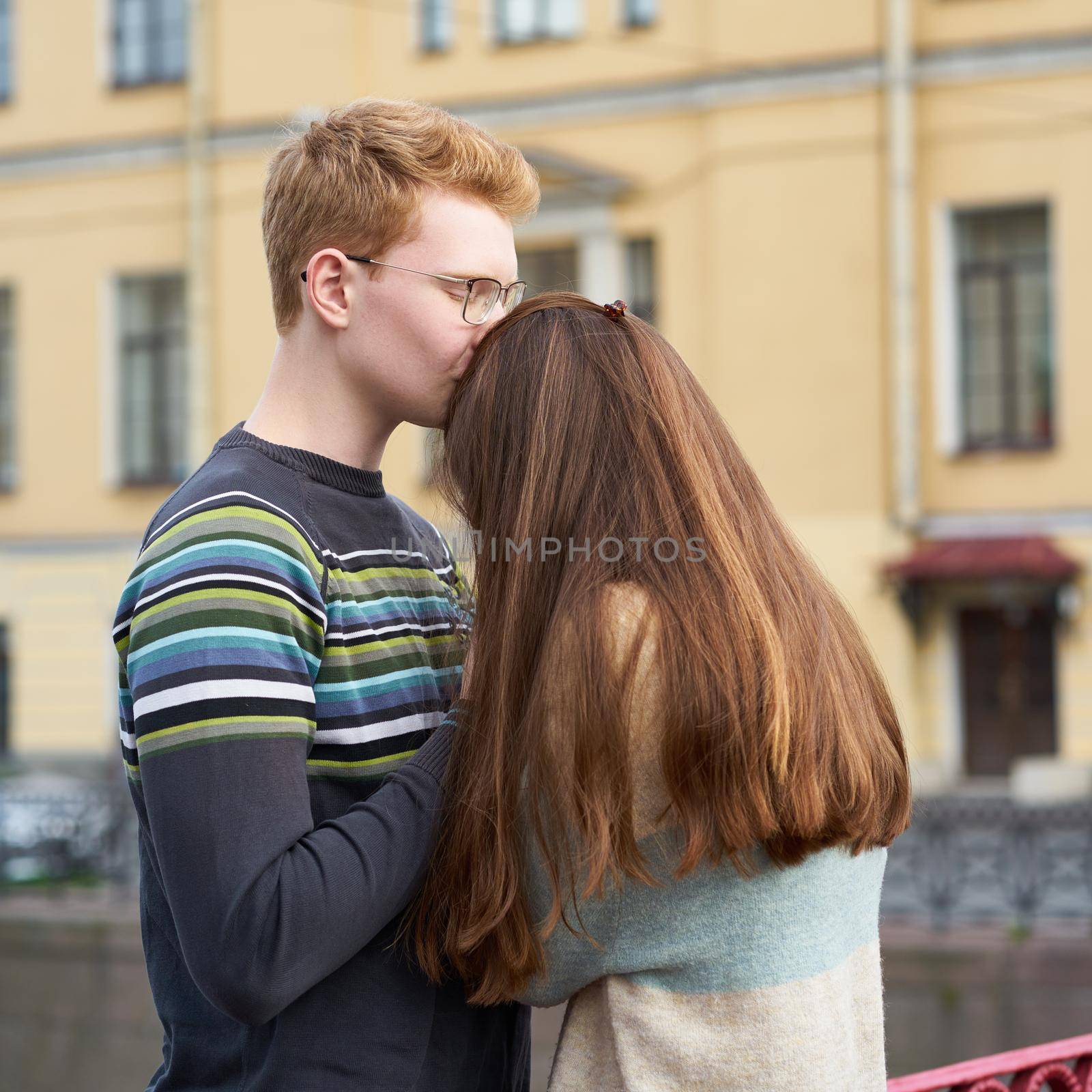 red-haired man kisses a woman on the top of her head, a boy in a sweater soothes and comforts a girl with long dark thick hair by NataBene