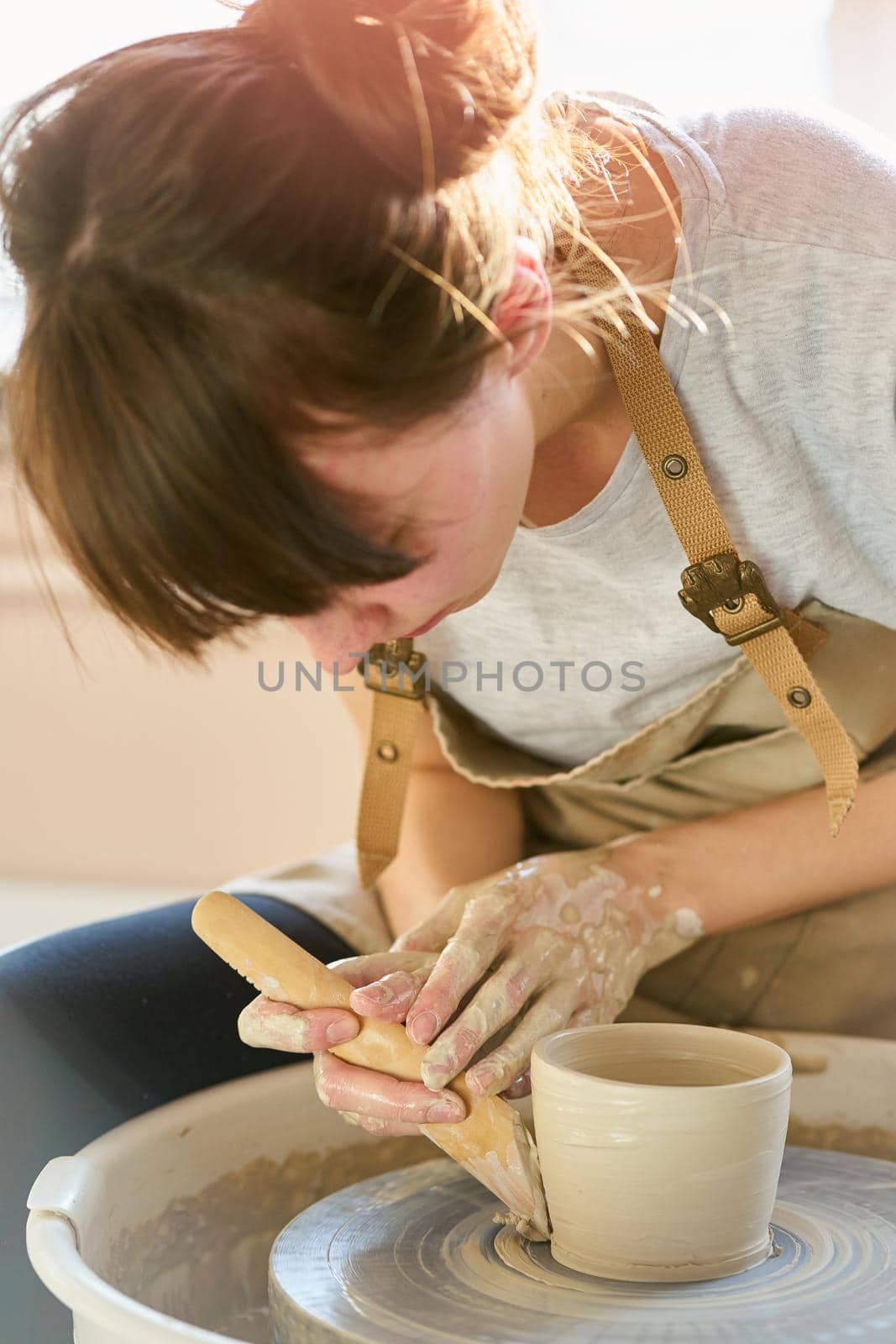 Woman making ceramic pottery on wheel, hands close-up. Concept for woman in freelance, business, hobby.