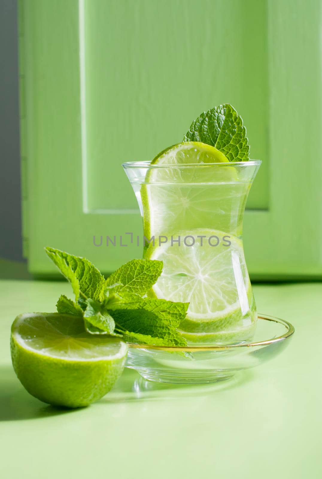 tea with mint and lime, with a calming effect, green still life close-up on a green background, top view. mojito, health drink, alternative medicine.High Quality Photo