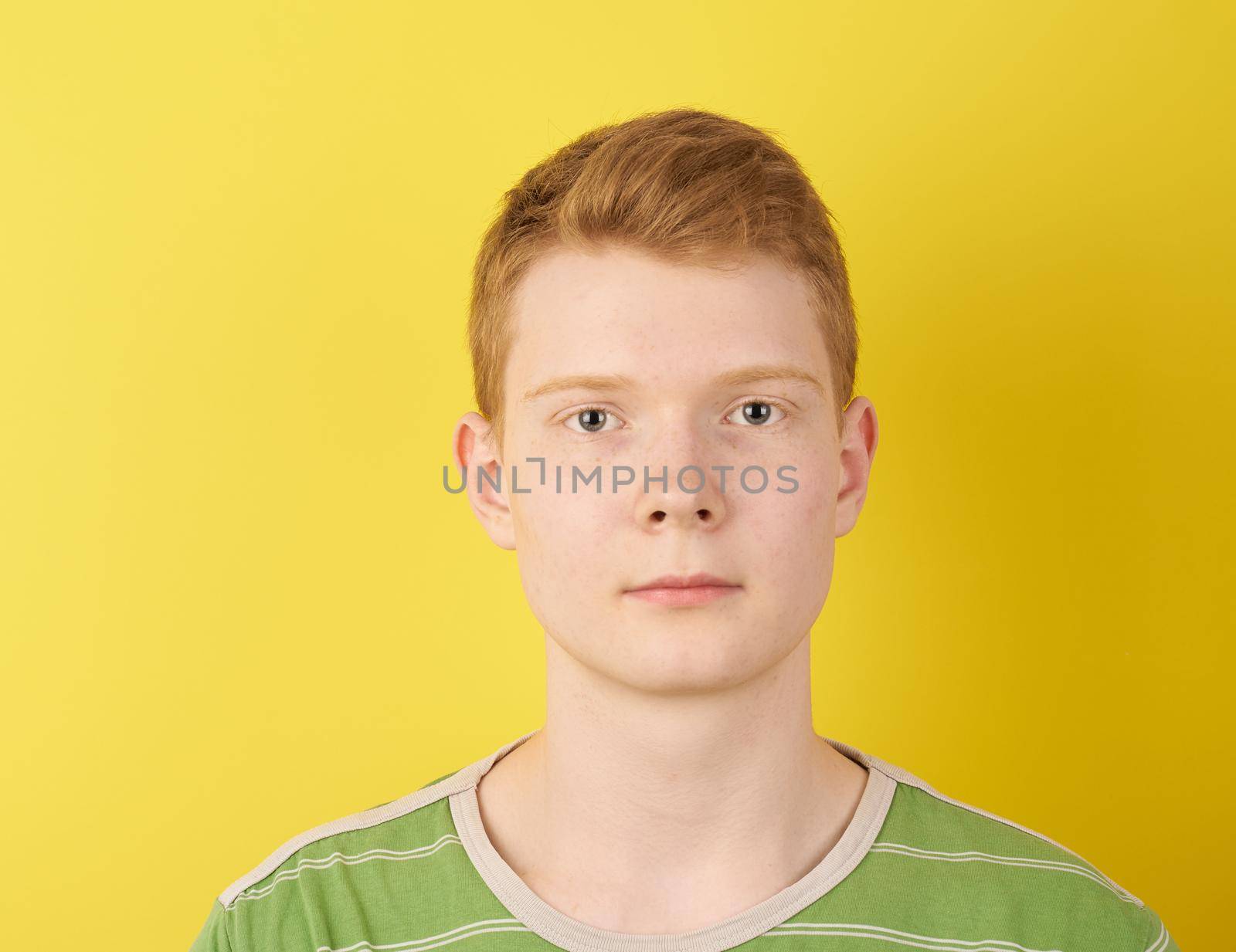 shaven teenager looks confident, wearing green t-shirt, ginger person portrait