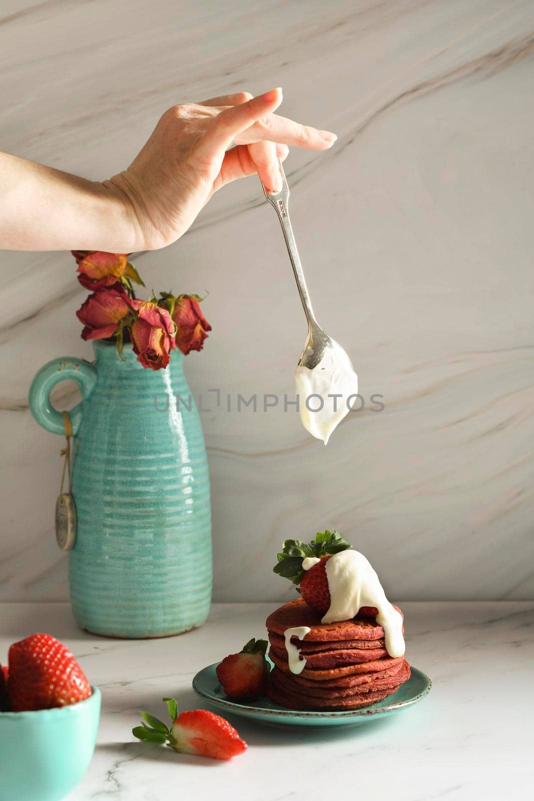 still life with pink strawberry pancakes on a turquoise plate with sour cream and fresh strawberries, cultural exotic food, creative breakfast for Valentine's holiday against a turquoise vase