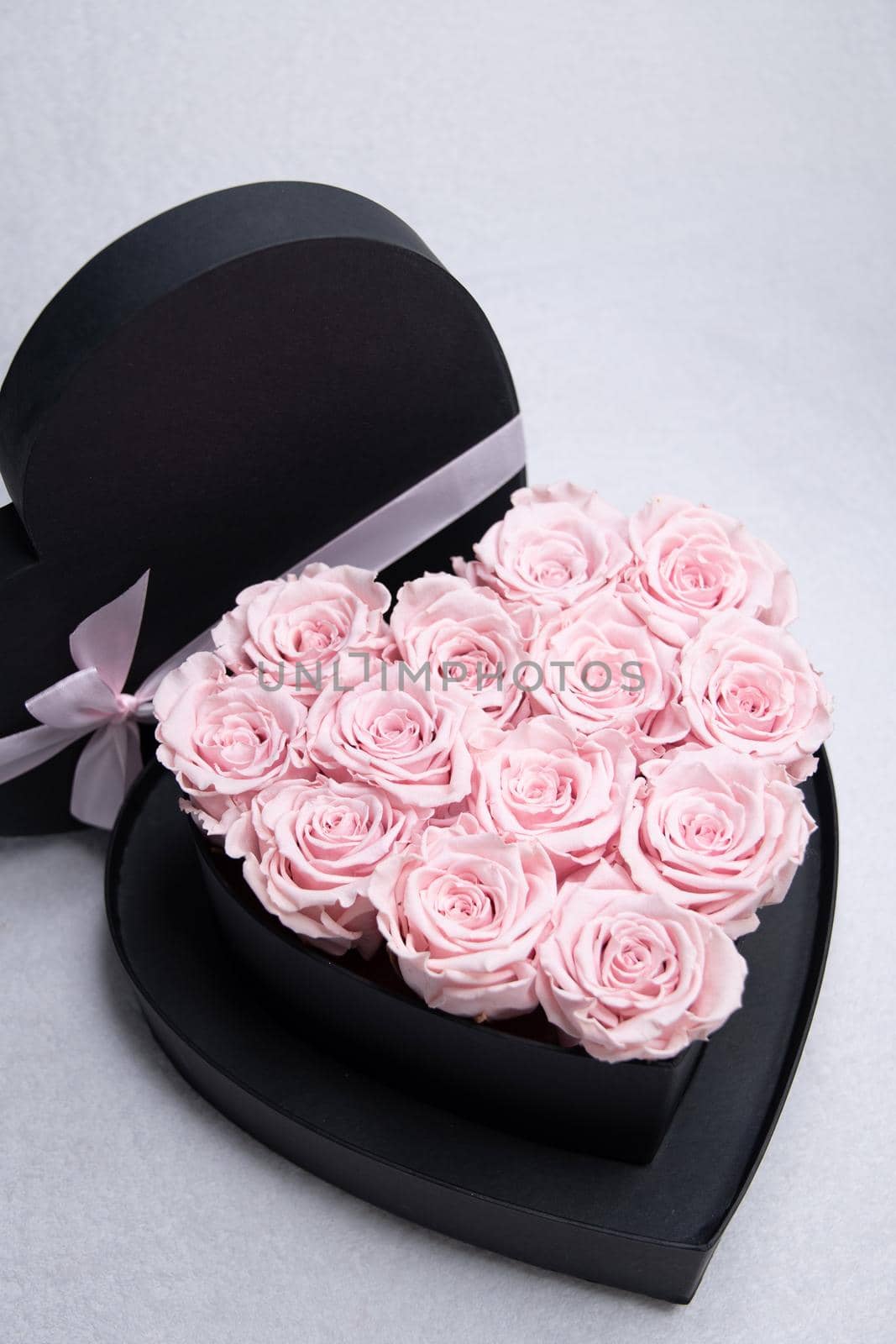 heart-shaped cardboard box with pink roses on the table, a gift for valentine's by KaterinaDalemans