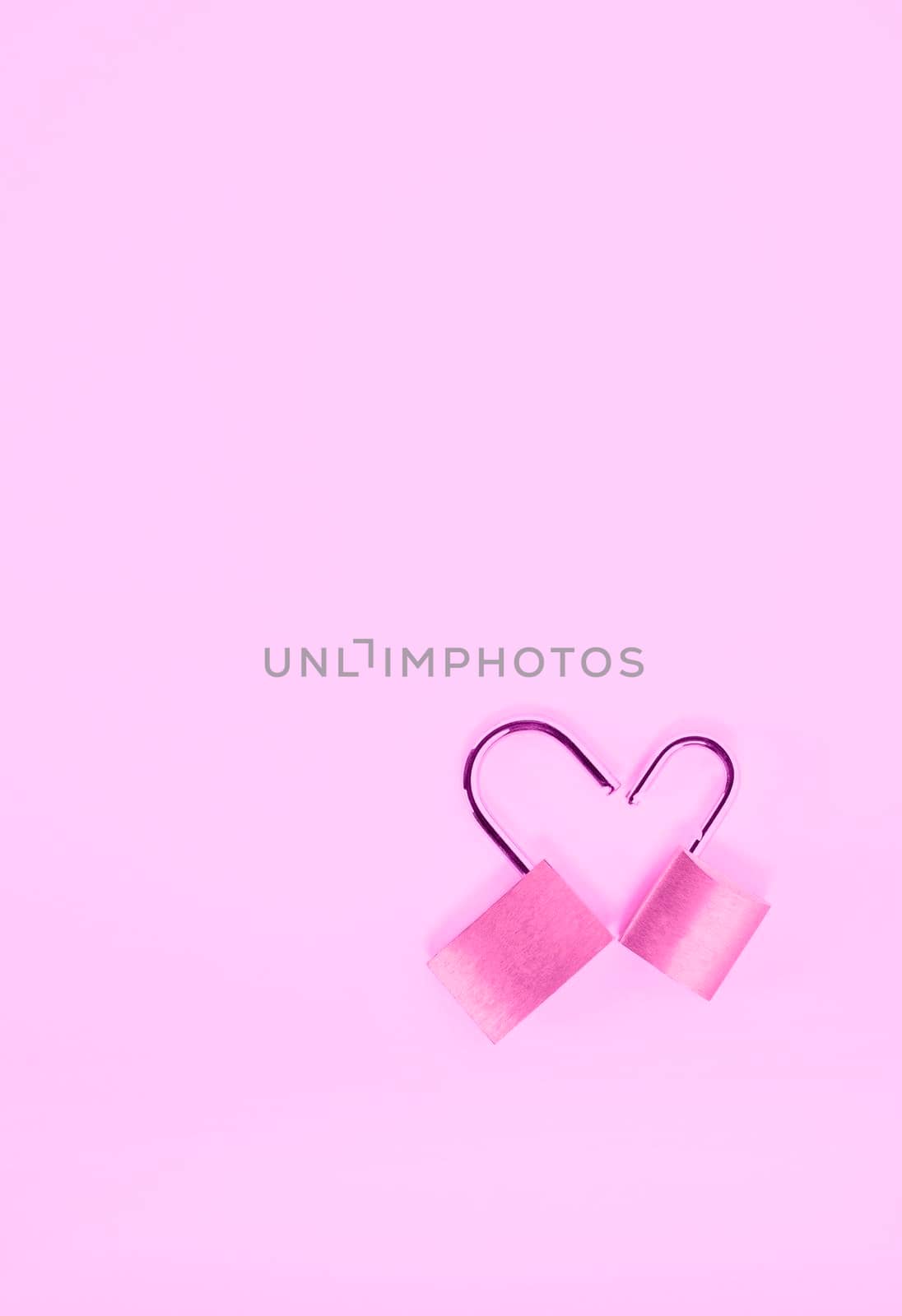 Two opened padlock in heart shape on pink background , passion and love