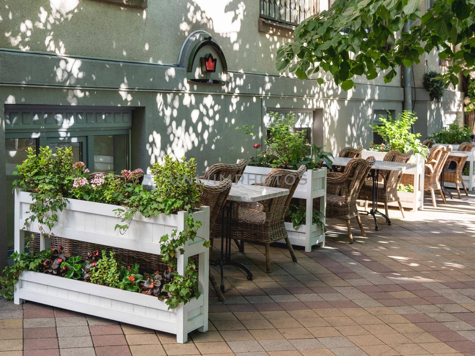 KRASNODAR, RUSSIA - June 02, 2021. Street cafe with flower beds and wicker furniture. by aksenovko