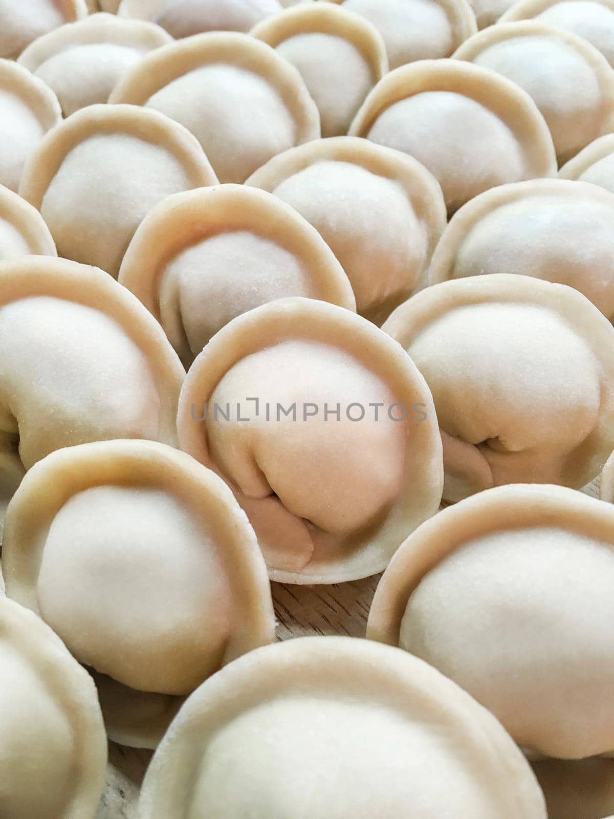 Full frame photo of meat pelmeni. Rows of handmade raw dumplings, traditional Russian food. by aksenovko