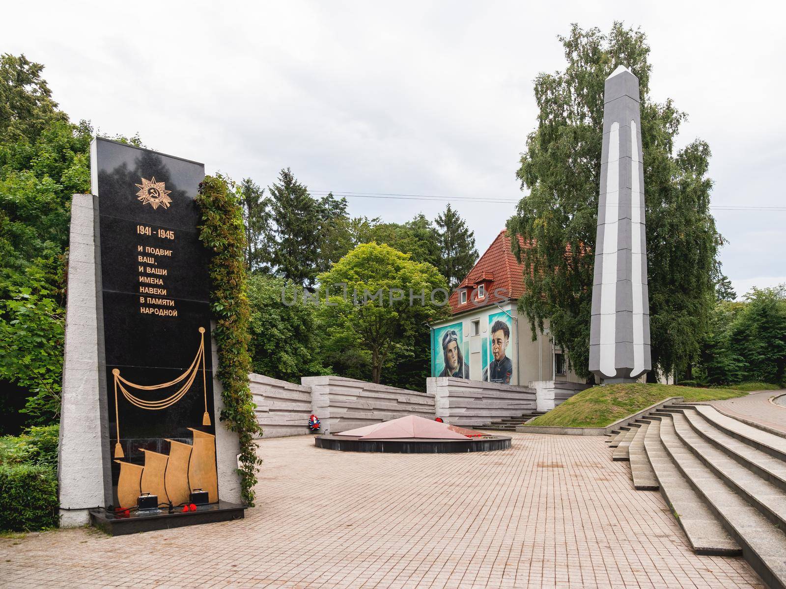 SVETLOGORSK, RUSSIA - July 21, 2019. Second World War memorial to war heroes. Monument and graffiti on house wall.