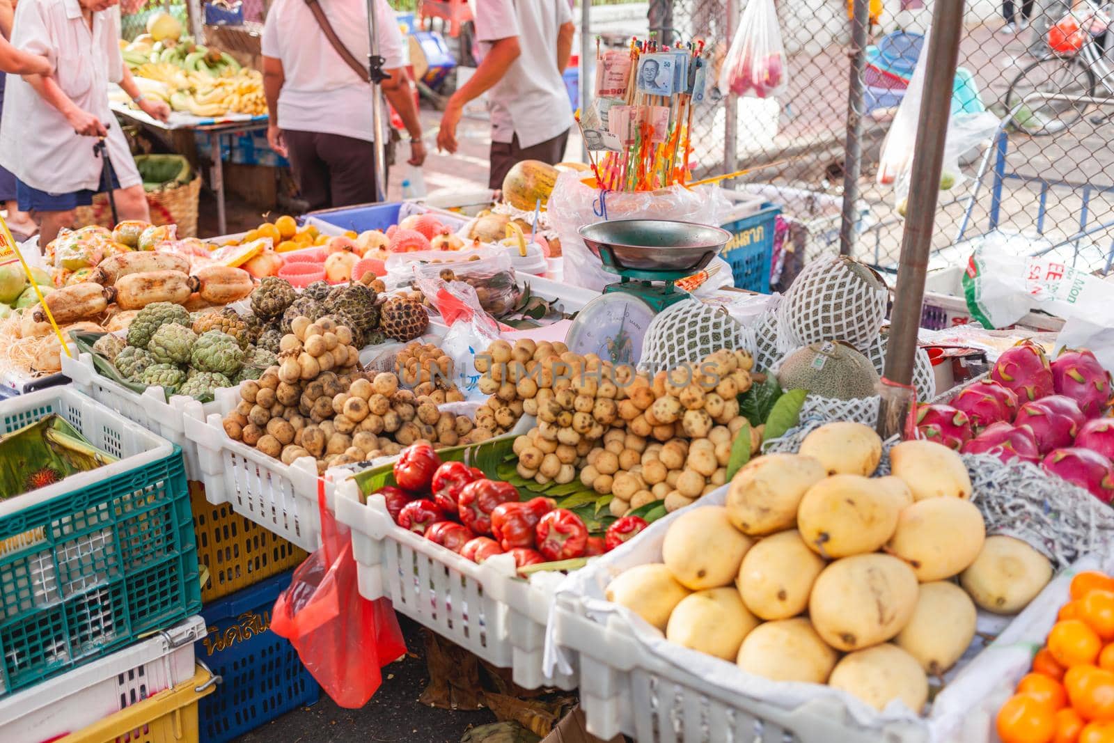 BANGKOK, THAILAND - October 23, 2012. Local people and tourists buy food on street market. Fruits and vegetables on stall.