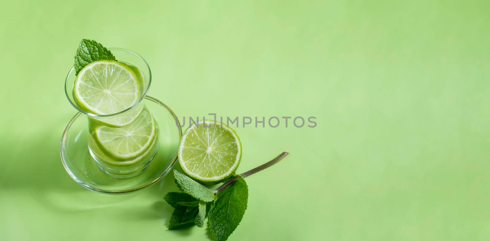 tea with mint and lime, with a calming effect, green still life close-up on a green background, top view. mojito, health drink, alternative medicine.High Quality Photo