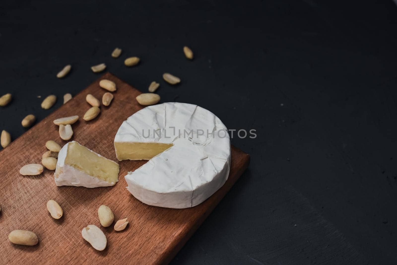 cheese camembert with mold and nuts on the wooden cutting board