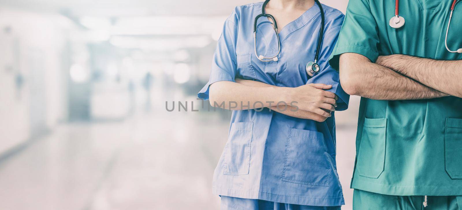 Two hospital staffs - surgeon, doctor or nurse standing with arms crossed in the hospital. Medical healthcare and doctor service.