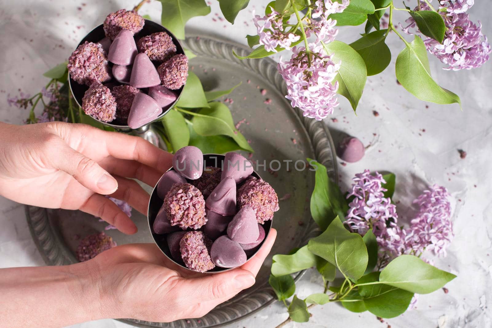Belgian sweets cuberdon and pralines in silver glasses, spring still life,lilac . High quality photo