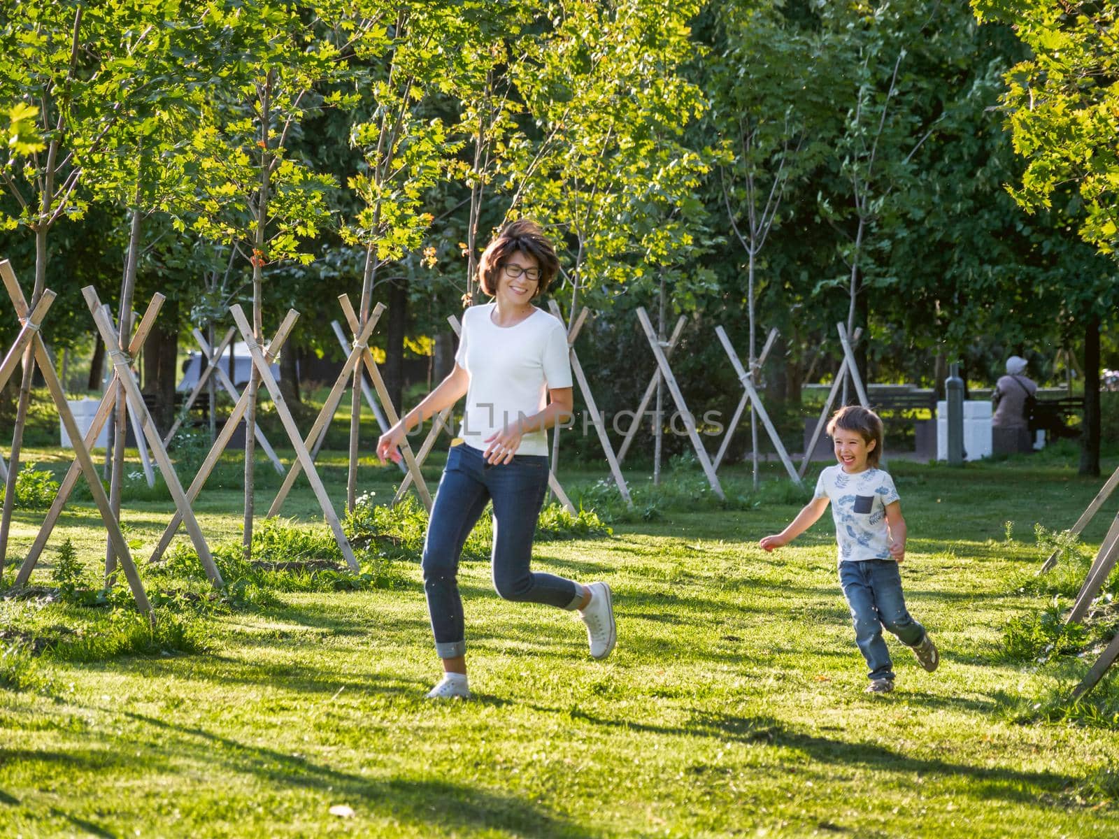 Family life. Mother and son play in park. Summer vibes. Active outdoor game. Lifestyle. Leisure activity open air. by aksenovko