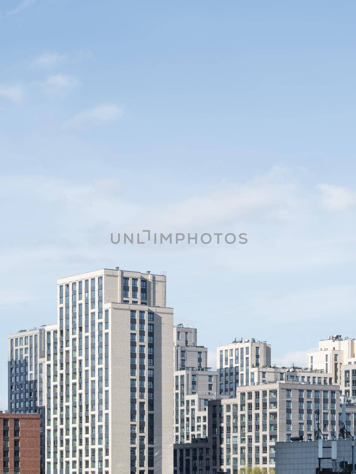 New residential district of Moscow. Modern architecture of apartment buildings. Vertical banner with clear blue sky. Russia.