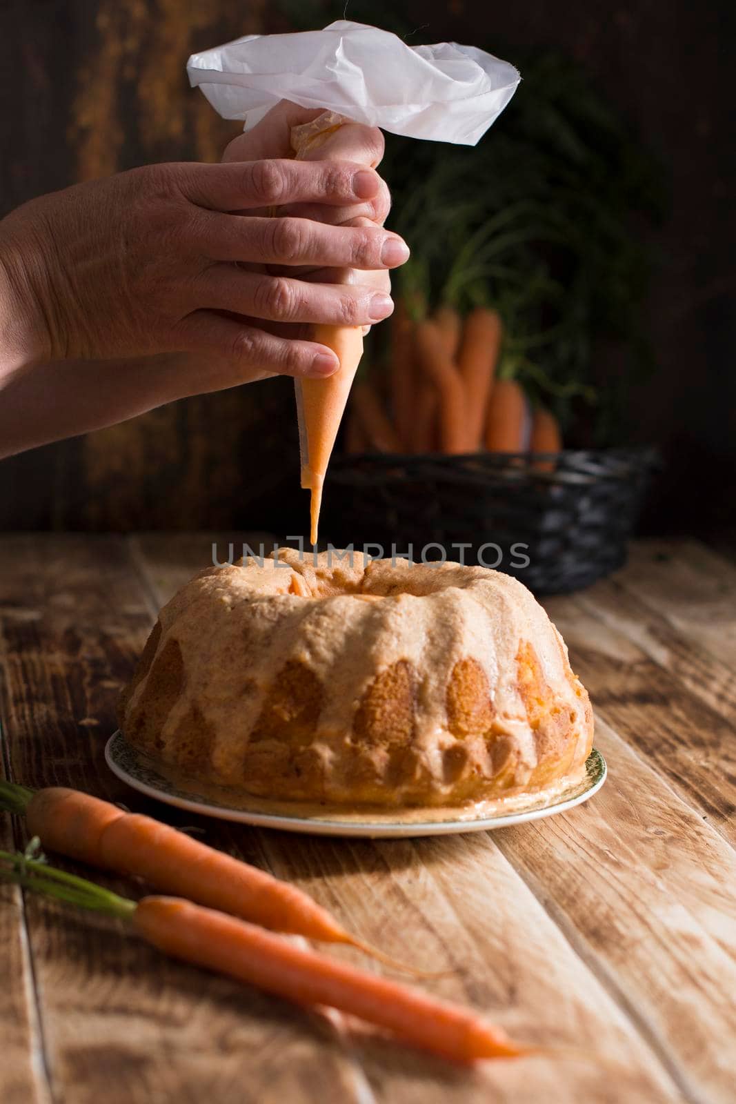 woman decorates carrot cupcake with sugar icing, homemade cakes, bake at home. High quality photo