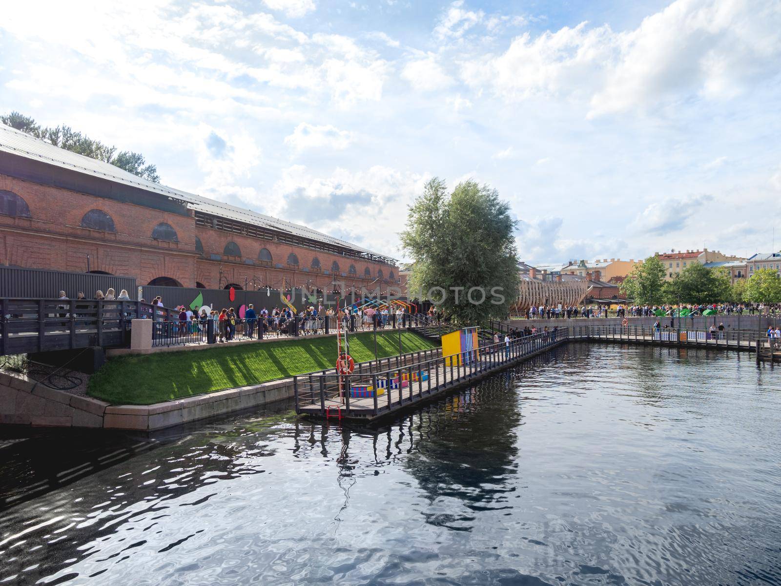 SAINT-PETERSBURG, RUSSIA - August 15, 2021. Panorama of New Holland island. Urban public park with playgrounds, garden and old buildings. by aksenovko