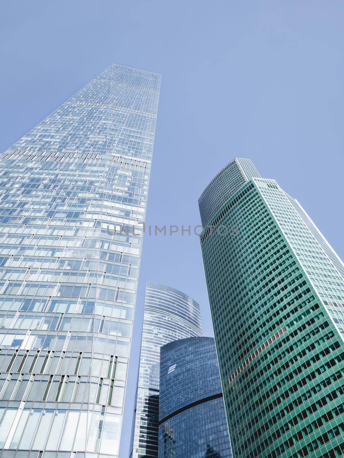 MOSCOW, RUSSIA - September 18, 2021. Bottom view on OKO buildings and Eurasia Tower of Moscow International Business Center. MIBC on clear blue sky background. by aksenovko