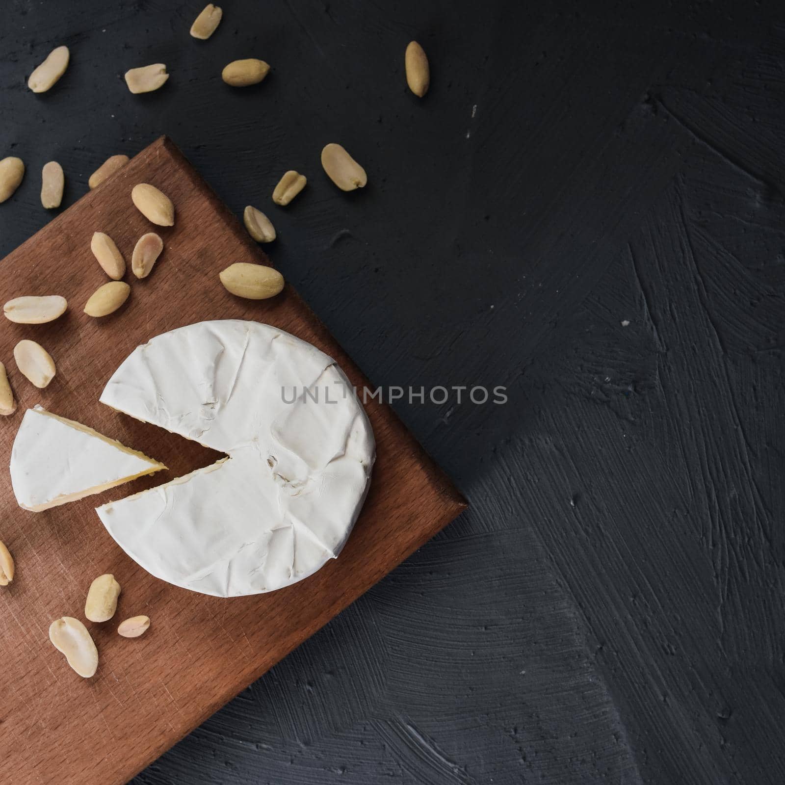 cheese camembert with mold and nuts on the wooden cutting board