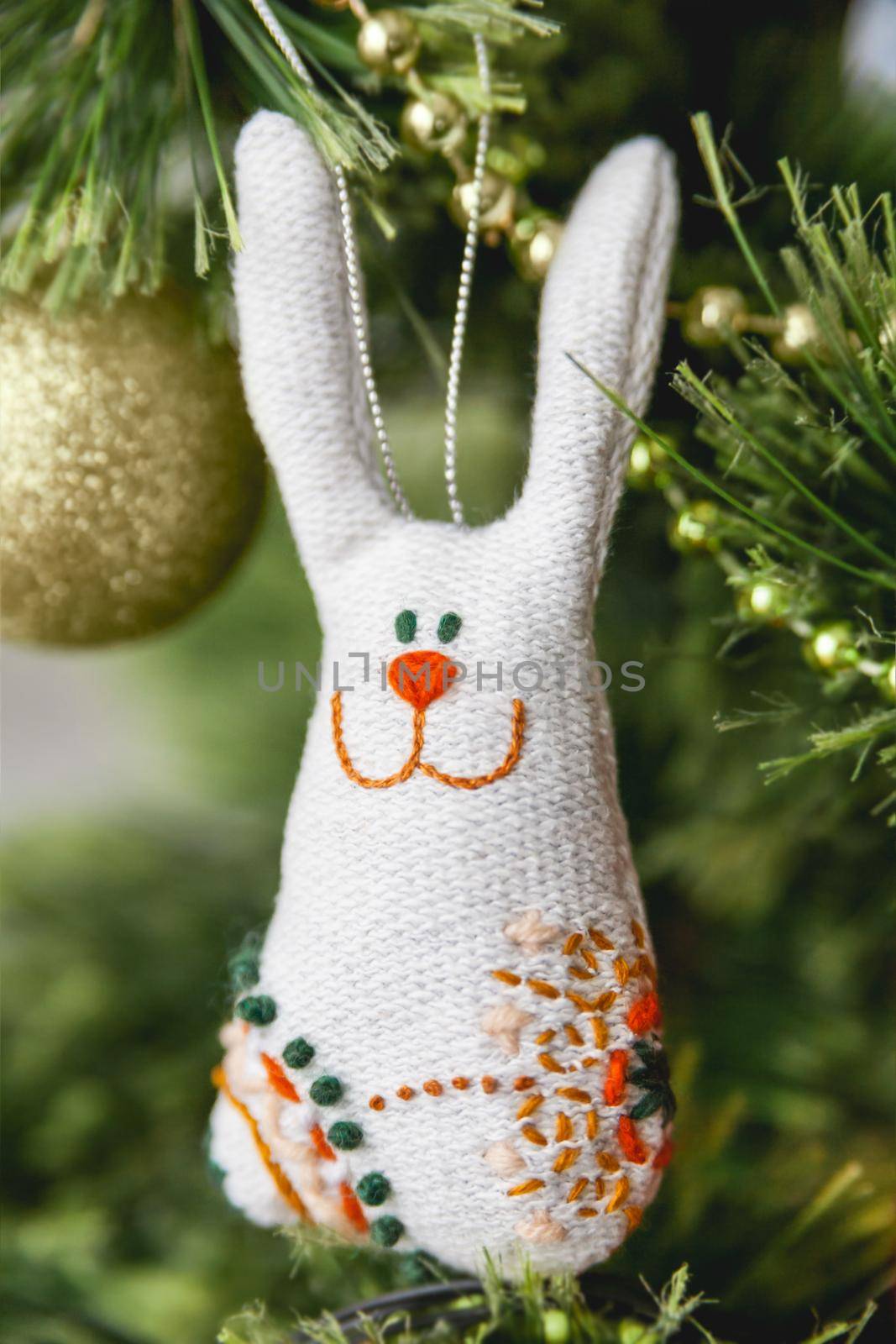 Hand made textile rabbit as Christmas tree decoration. Embroidered hare as symbol of New Year 2023.