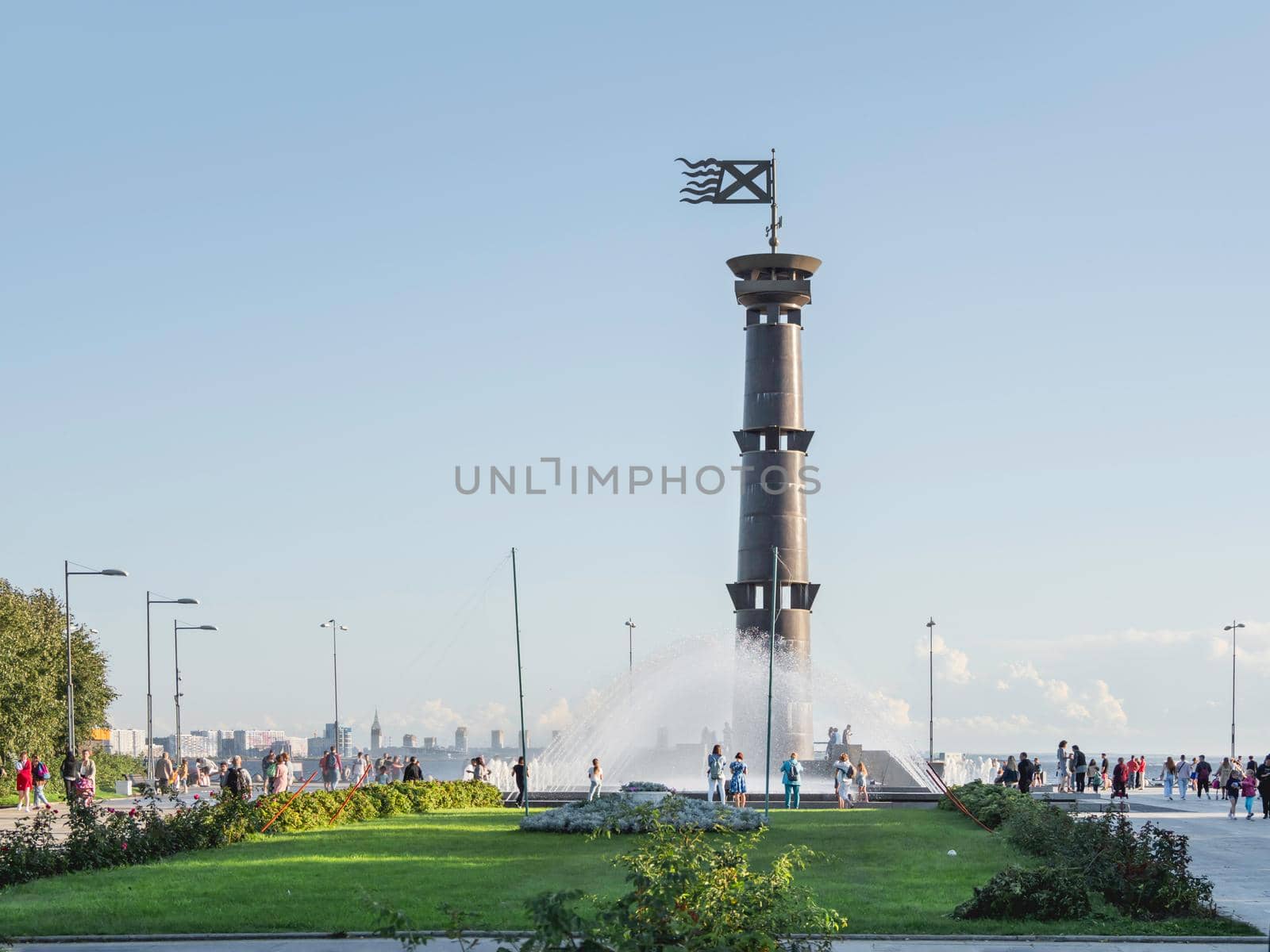 SAINT-PETERSBURG, RUSSIA - August 13, 2021. People walk near Column Lighthouse in Park of 300th anniversary of St. Petersburg. by aksenovko