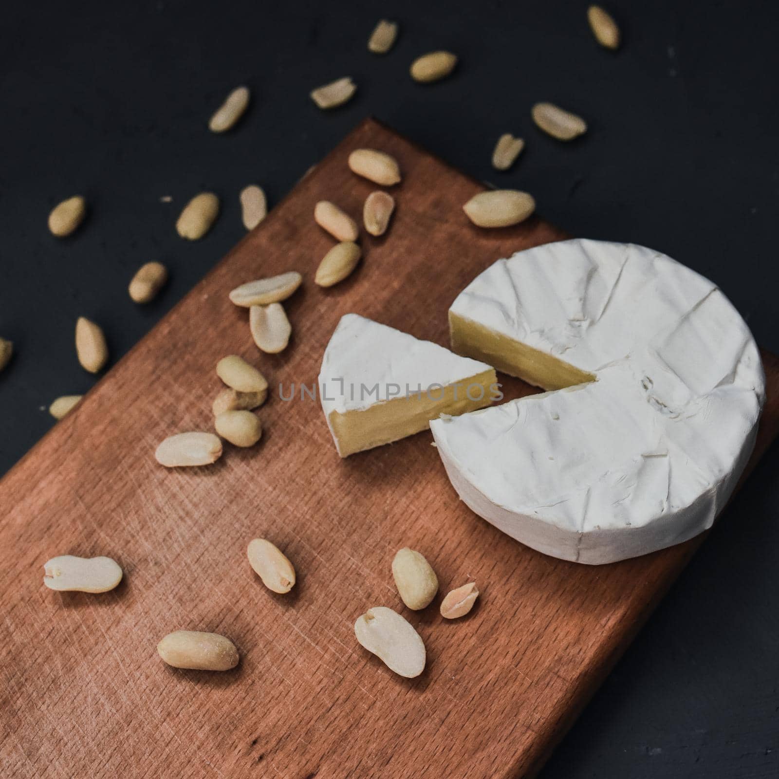 cheese camembert with mold and nuts on wooden board by AndriiDrachuk