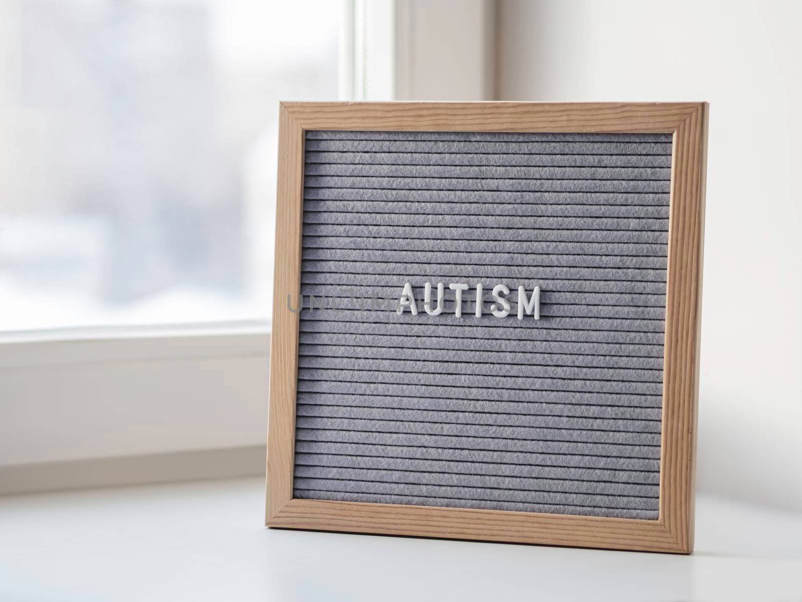 Grey letterboard with word Autism. Medical diagnosis which usually made in childhood. Drawing attention to development of children. by aksenovko