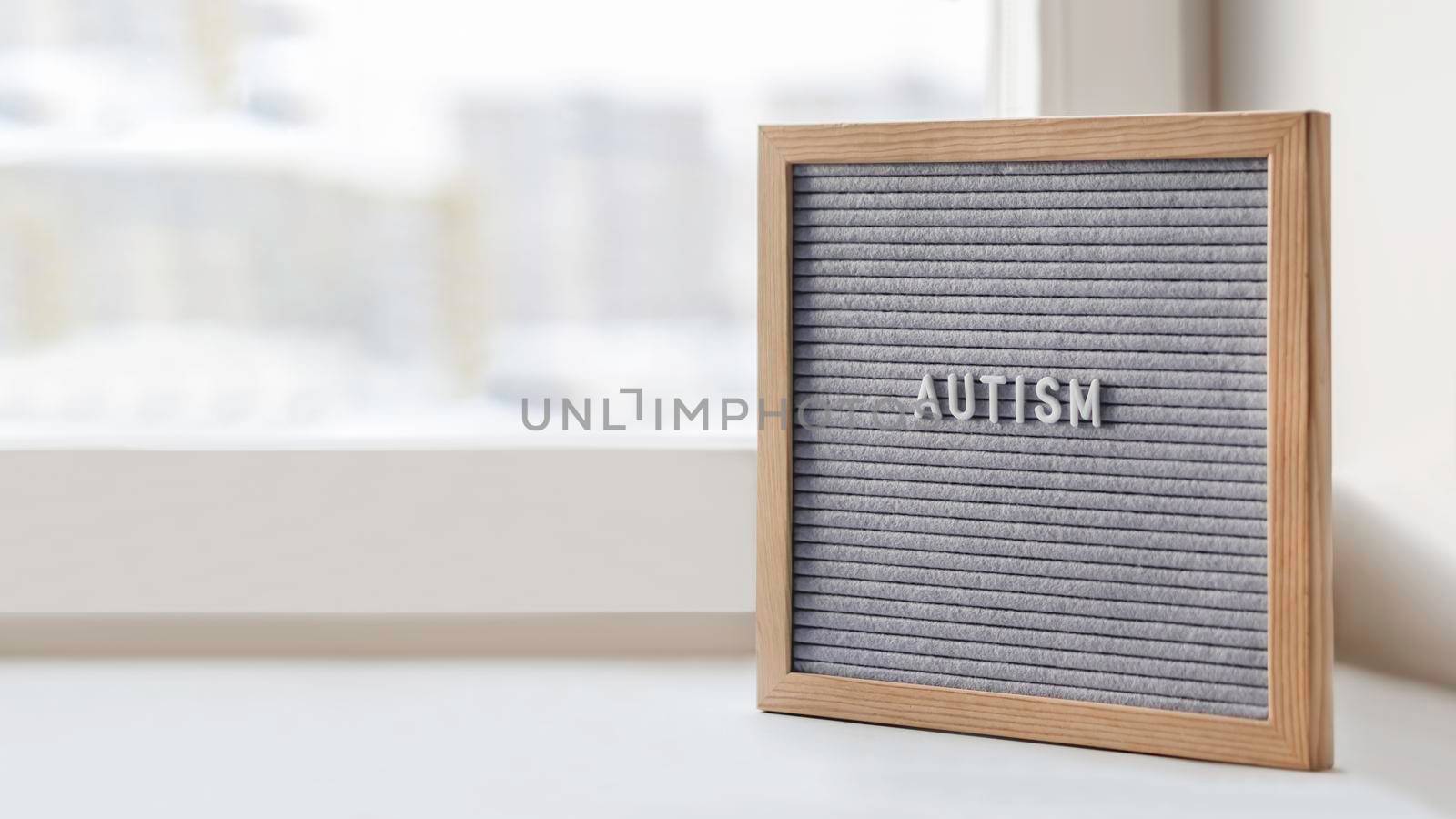 Grey letterboard with word Autism. Medical diagnosis which usually made in childhood. Drawing attention to development of children. Copy space. by aksenovko