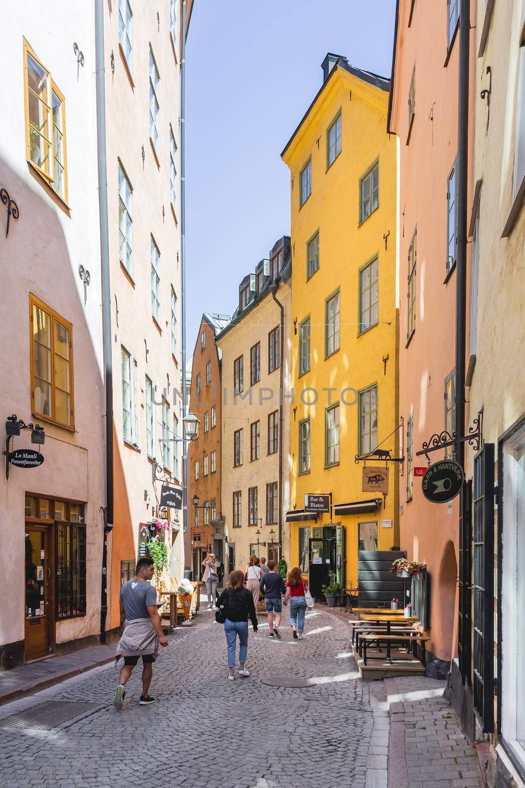 STOCKHOLM, SWEDEN - July 06, 2017. Tourists walk on narrow streets in historic part of town. Old fashioned buildings in Gamla stan.